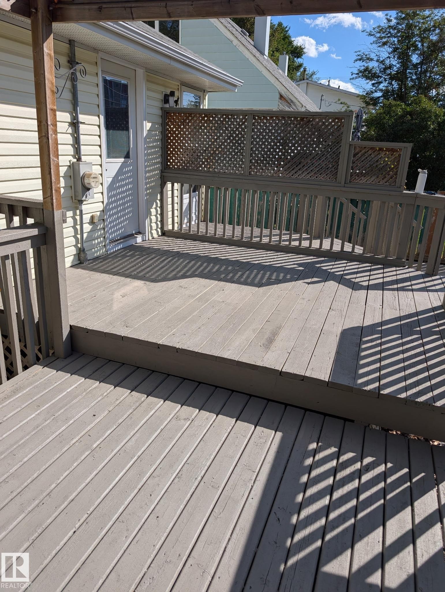 Multi-level deck featuring wood construction, lattice privacy screening, and a direct entrance to the residence - 11836 62 Street Nw, Edmonton, AB