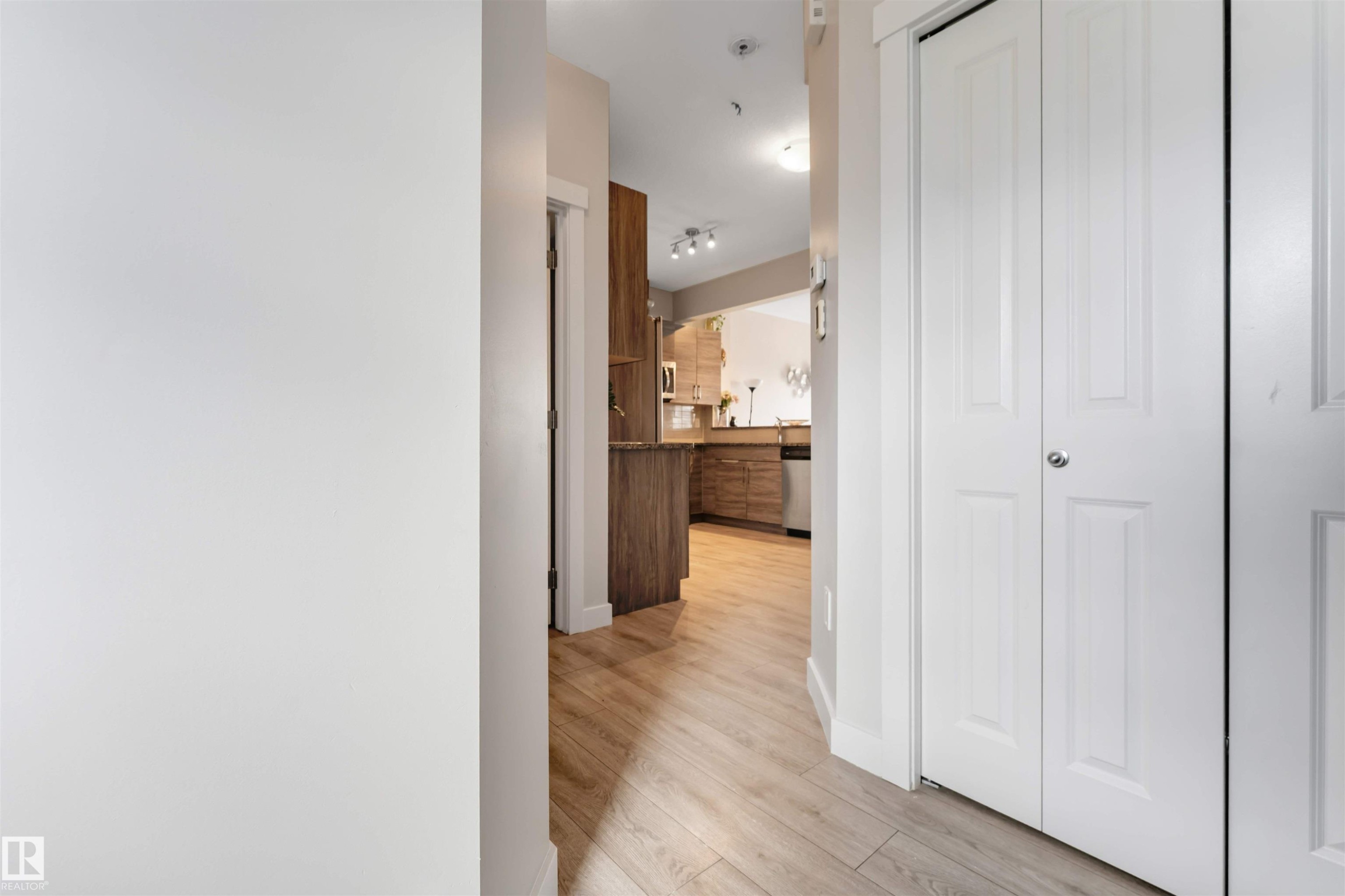 Wood-finish flooring throughout, white paneled bi-fold doors, and recessed lighting - 2004 15 Avenue Nw, Edmonton, AB