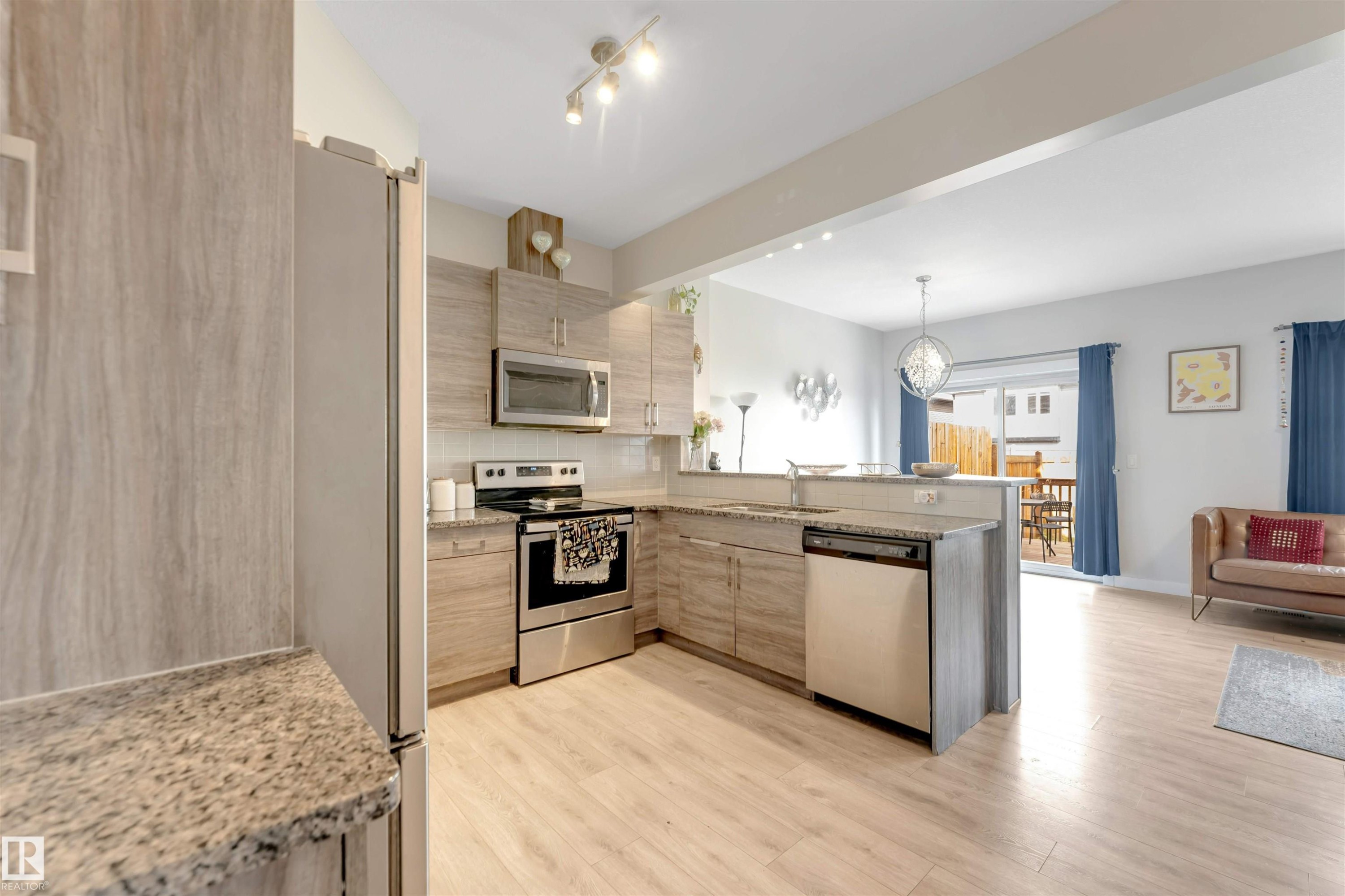 Contemporary kitchen featuring light wood-finish cabinetry, granite-style countertops, and stainless steel appliances - 2004 15 Avenue Nw, Edmonton, AB
