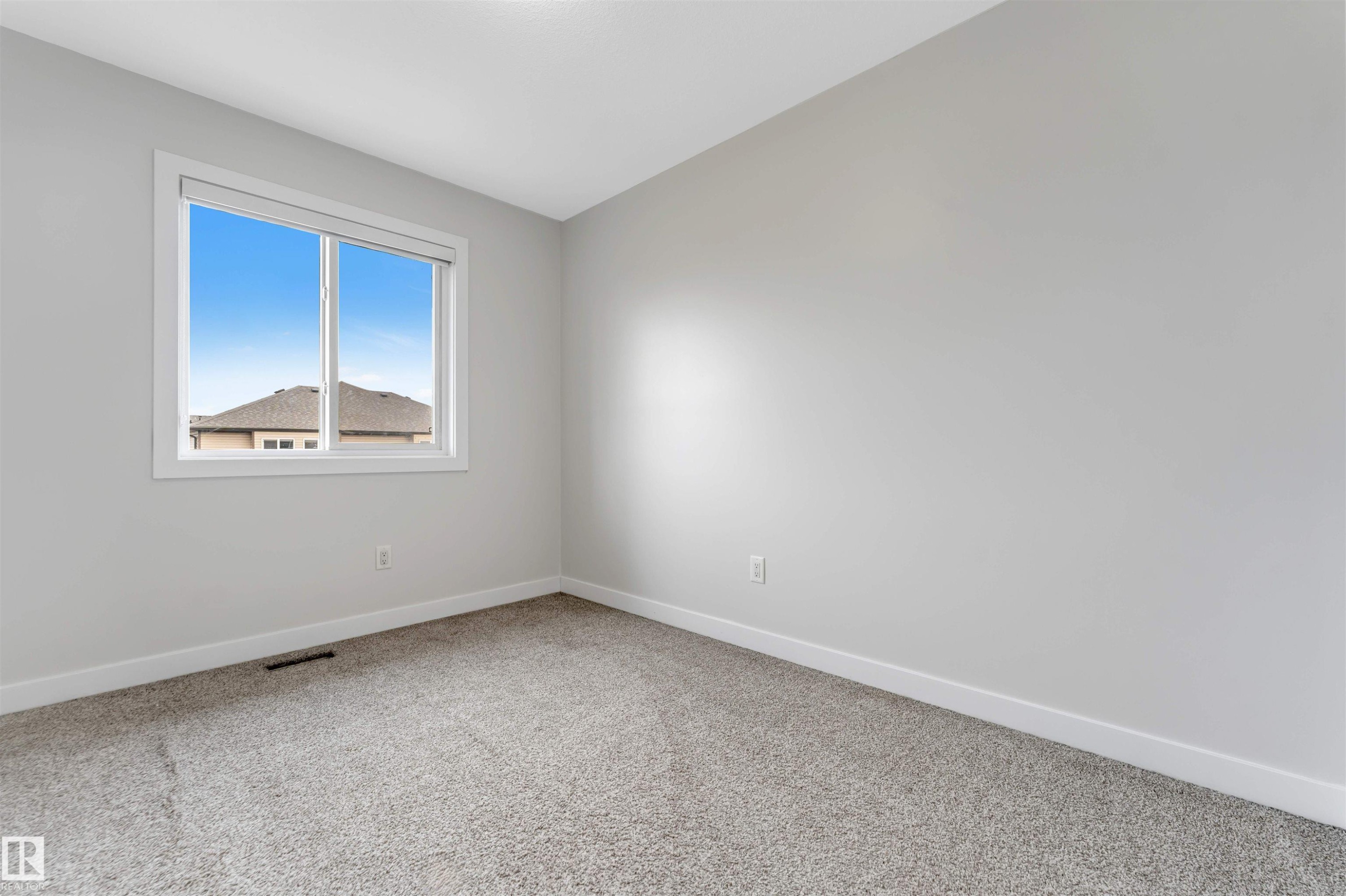 Spacious room featuring light gray walls, white trim, and gray carpet - 2004 15 Avenue Nw, Edmonton, AB