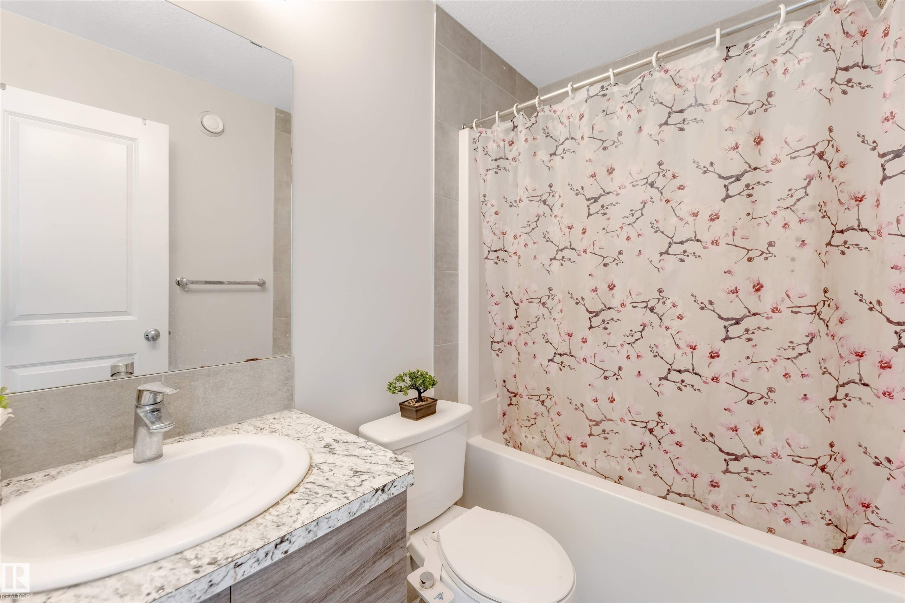 Vanity with integrated sink, stone-finish countertop, and chrome faucet - 2004 15 Avenue Nw, Edmonton, AB