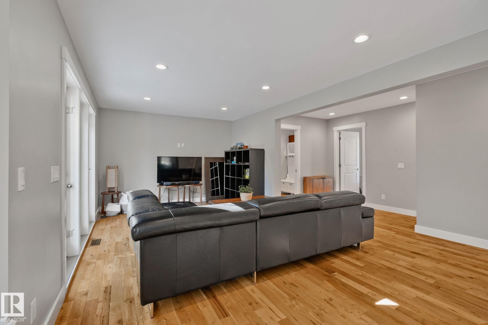 Open-concept living space featuring wood-finish flooring, recessed lighting, and large window panels - 12403 29A Avenue Nw, Edmonton, AB