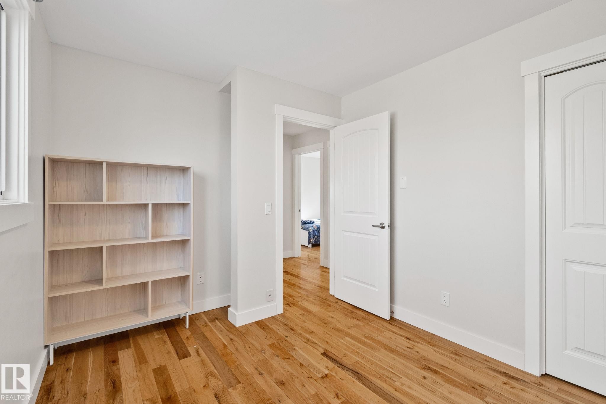 Hardwood flooring, white walls, white interior doors, and a built-in closet - 12403 29A Avenue Nw, Edmonton, AB