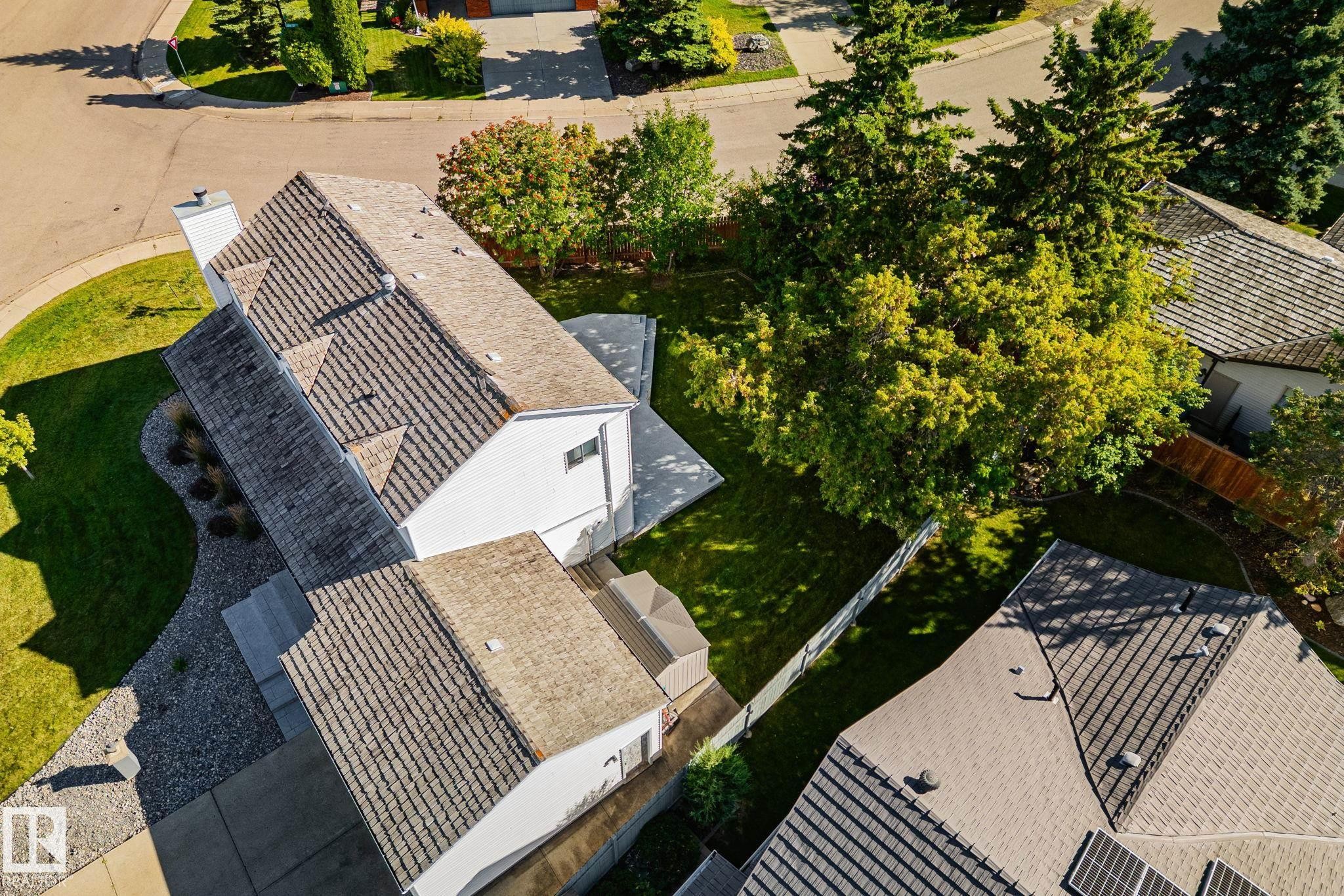 Gable roofline with dormer windows, white siding exterior, paved driveway, mature trees, and a manicured lawn - 12403 29A Avenue Nw, Edmonton, AB