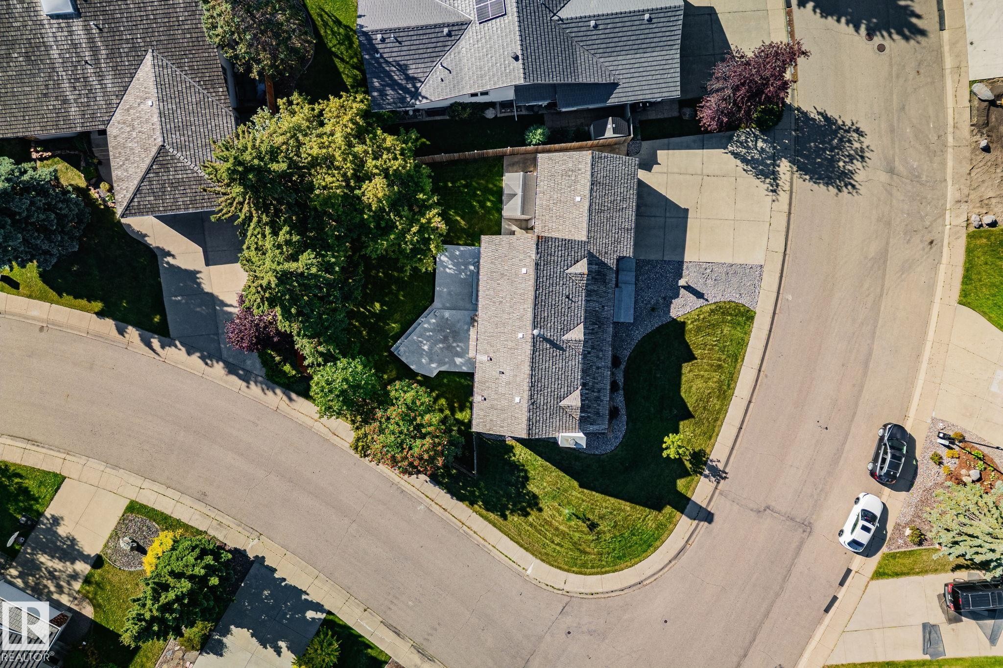 Stone veneer exterior, gabled roofline, concrete driveway, mature trees, manicured lawn - 12403 29A Avenue Nw, Edmonton, AB