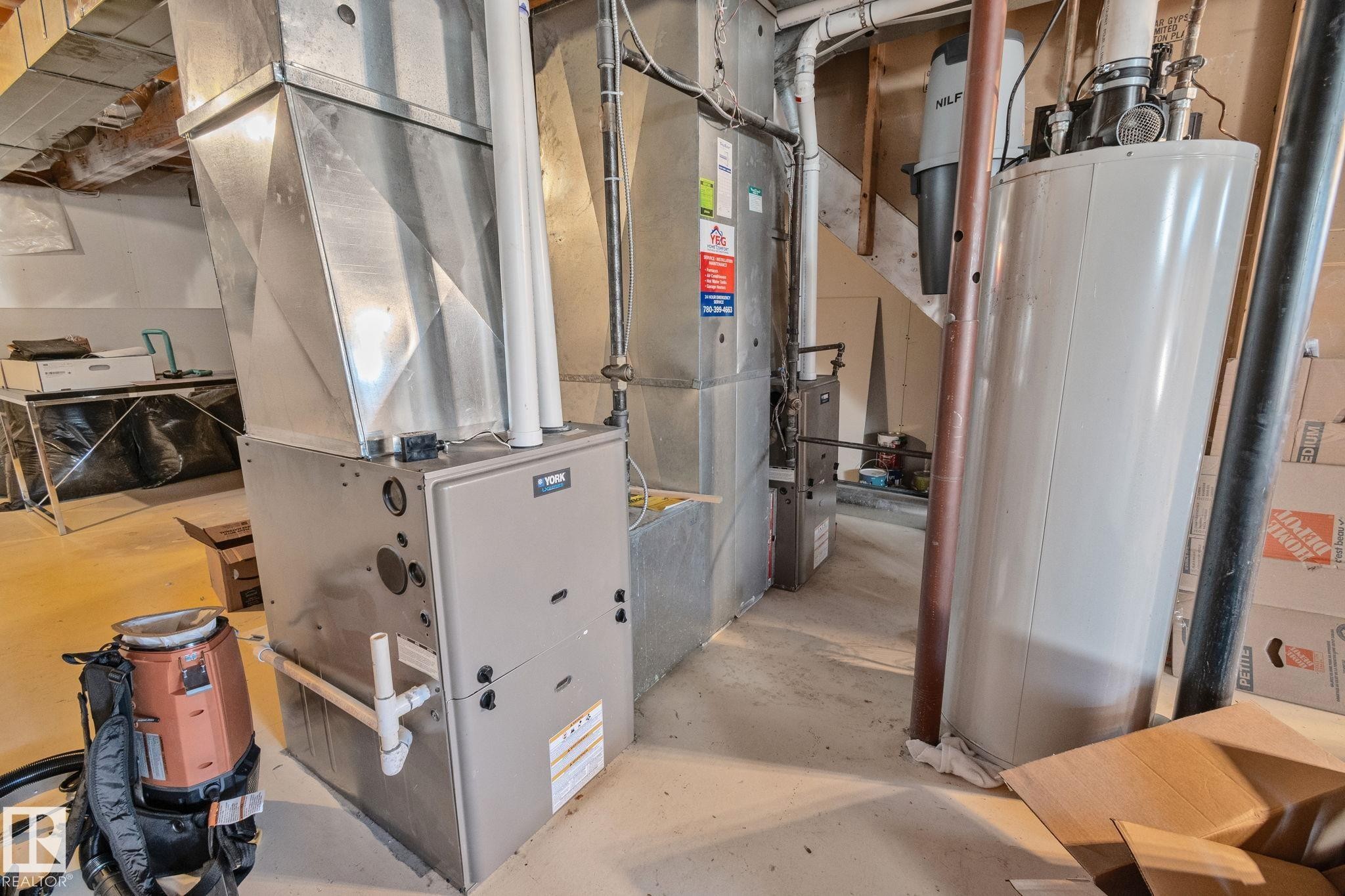 York furnace with metal ductwork, water heater, and exposed overhead joists - 12403 29A Avenue Nw, Edmonton, AB