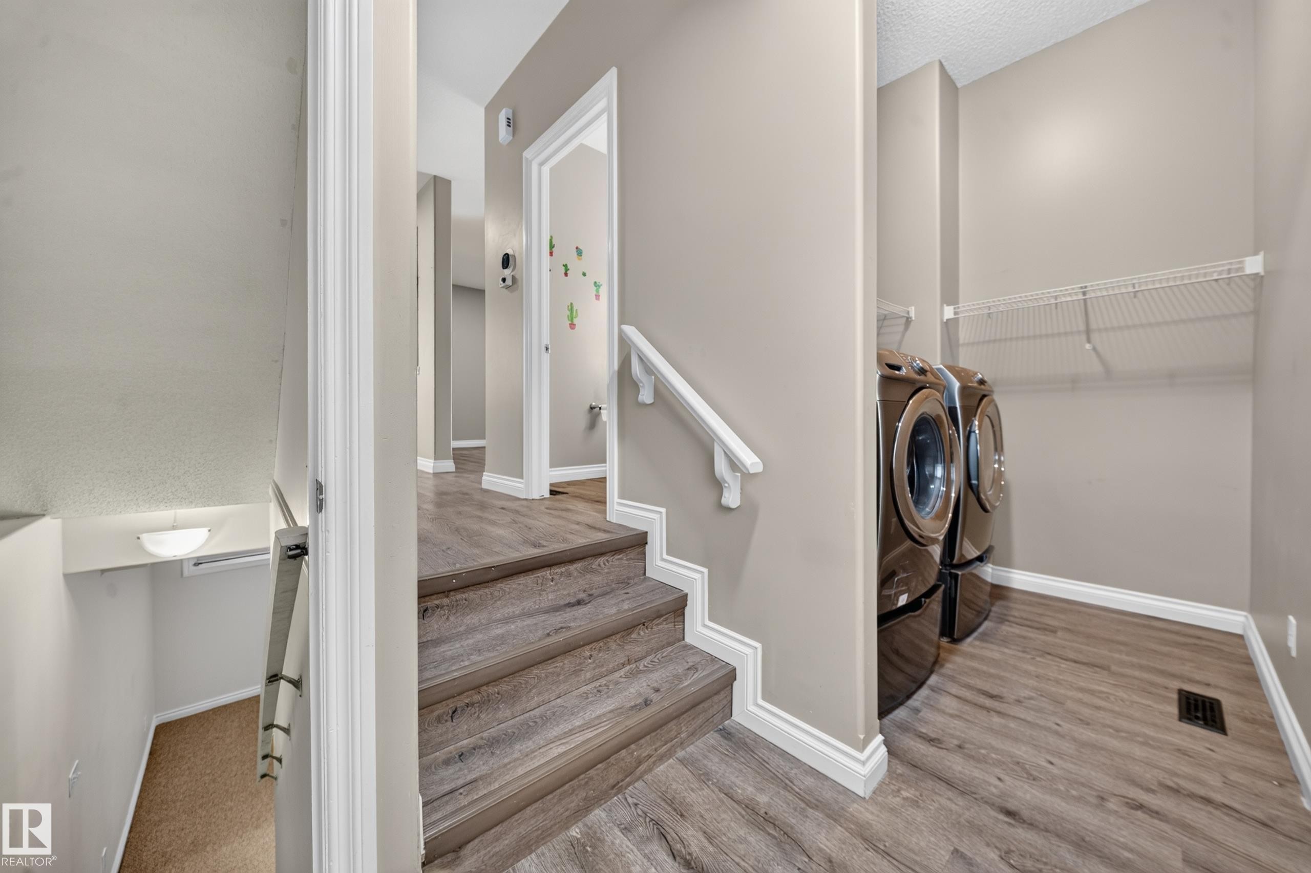 Wood-finish flooring throughout, featuring a built-in laundry area with shelving - 121 64 Street Sw, Edmonton, AB