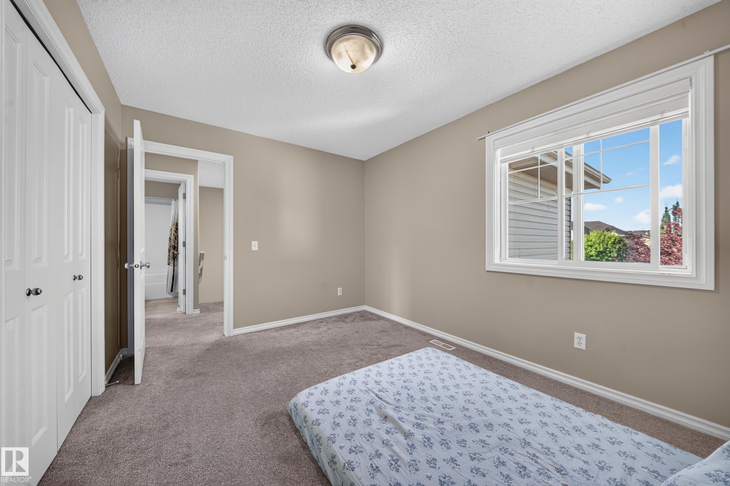 Carpeted flooring, neutral wall paint, overhead flush-mount lighting, and a window with white blinds - 121 64 Street Sw, Edmonton, AB