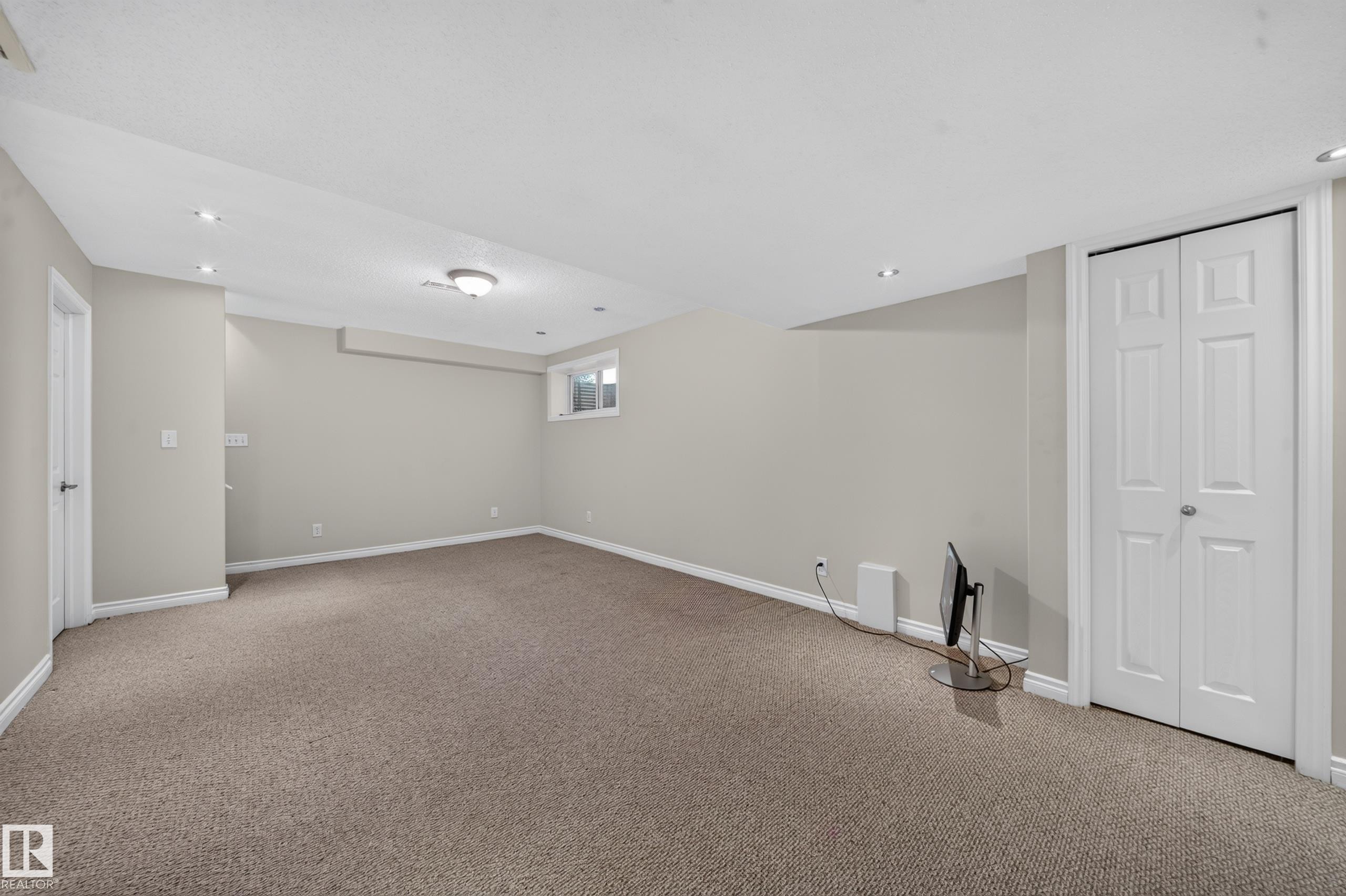 Recessed lighting, flush mount ceiling fixture, window, bi-fold closet doors, and light gray wall finish - 121 64 Street Sw, Edmonton, AB