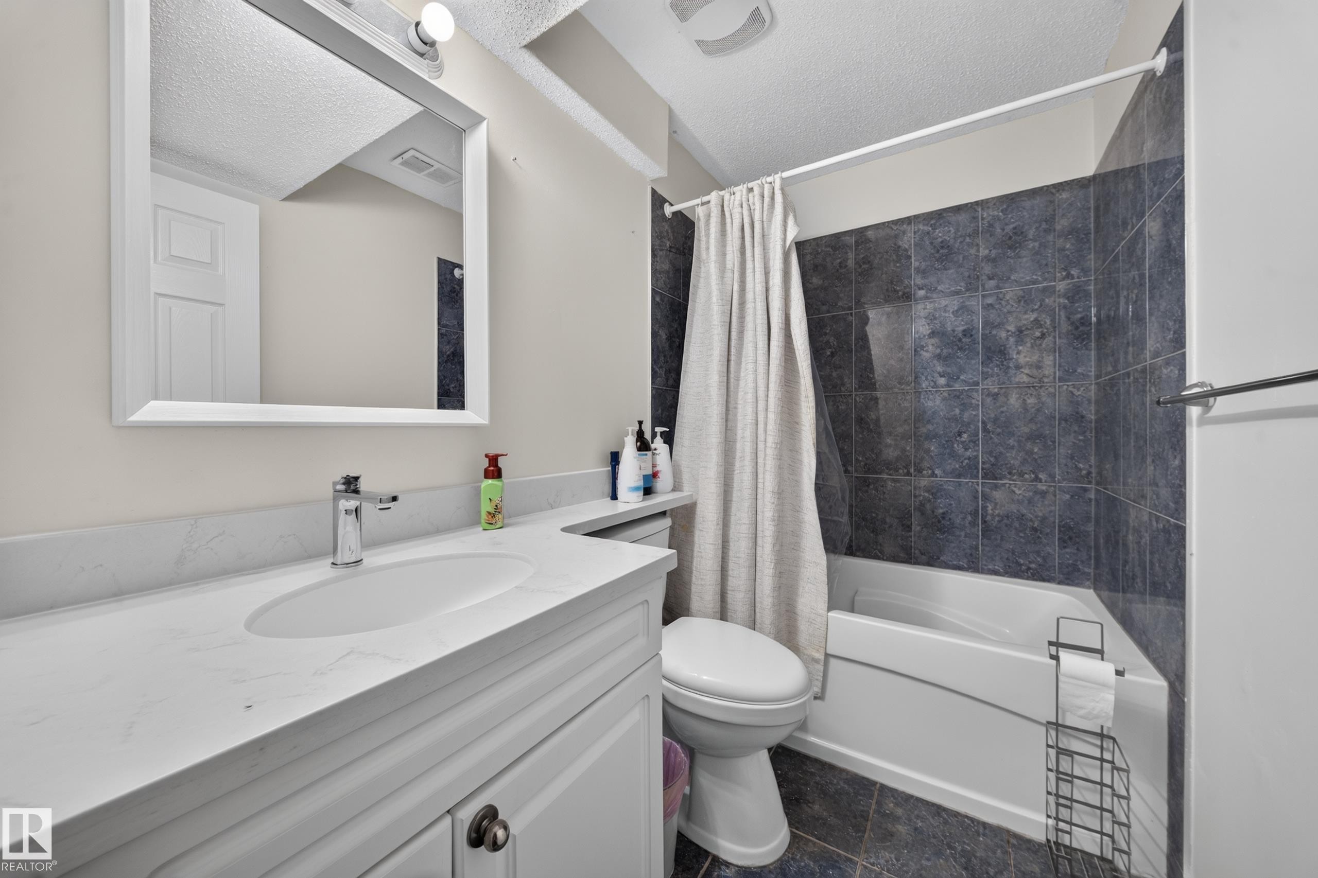 White vanity with an integrated sink and chrome faucet - 121 64 Street Sw, Edmonton, AB