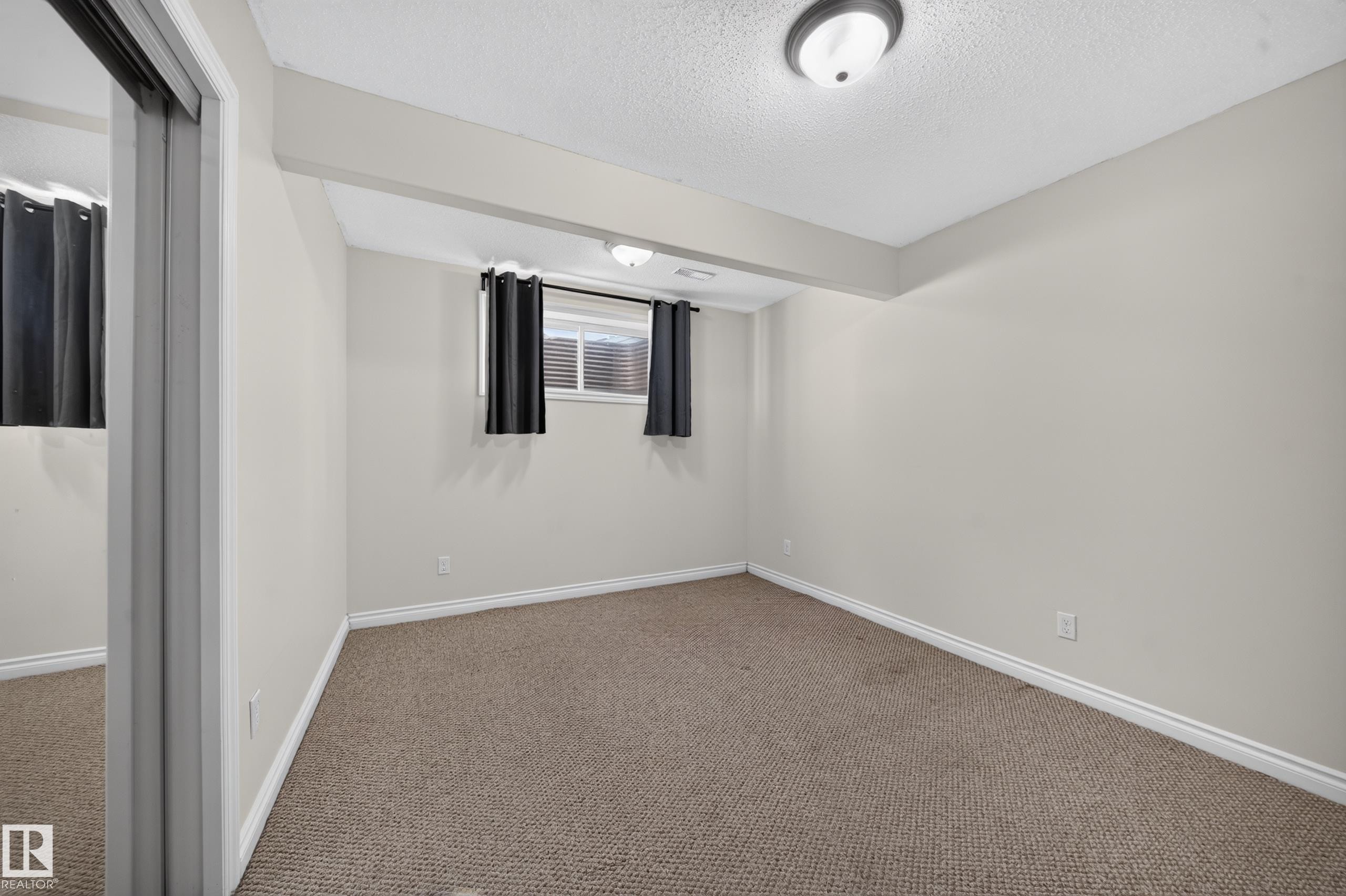 Neutral-toned walls complement the textured carpet flooring - 121 64 Street Sw, Edmonton, AB