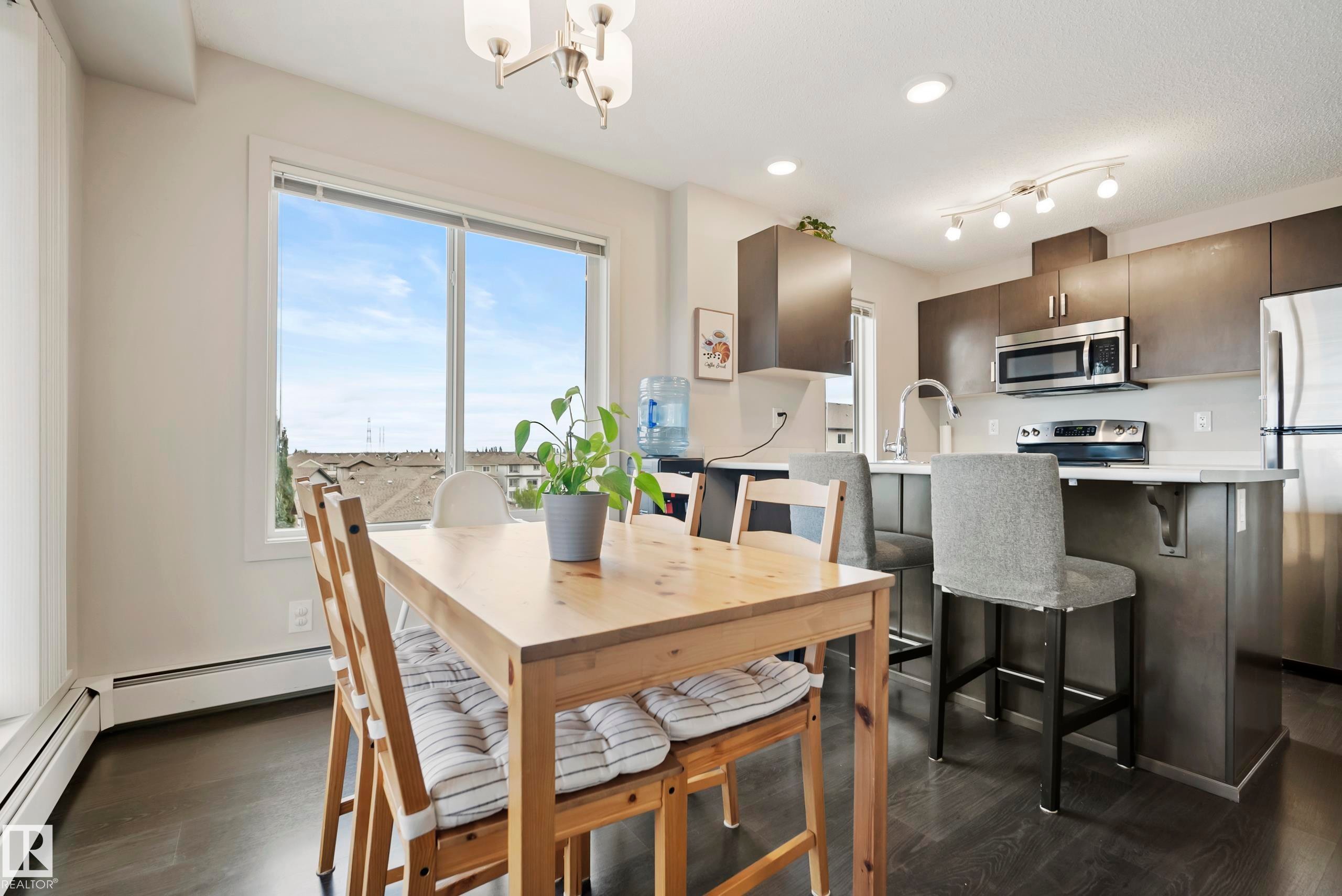 Kitchen with stainless steel appliances, dark wood-finish flooring, and white countertops - #419 5515 7 Av Sw, Edmonton, AB