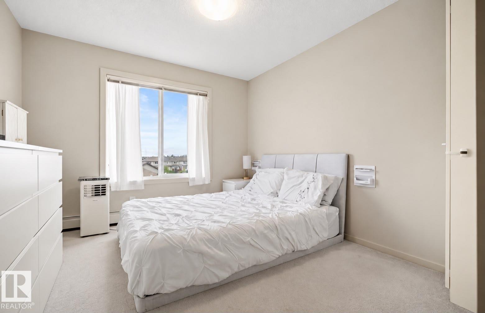 Wall-to-wall carpeting and a window with white trim - #419 5515 7 Av Sw, Edmonton, AB