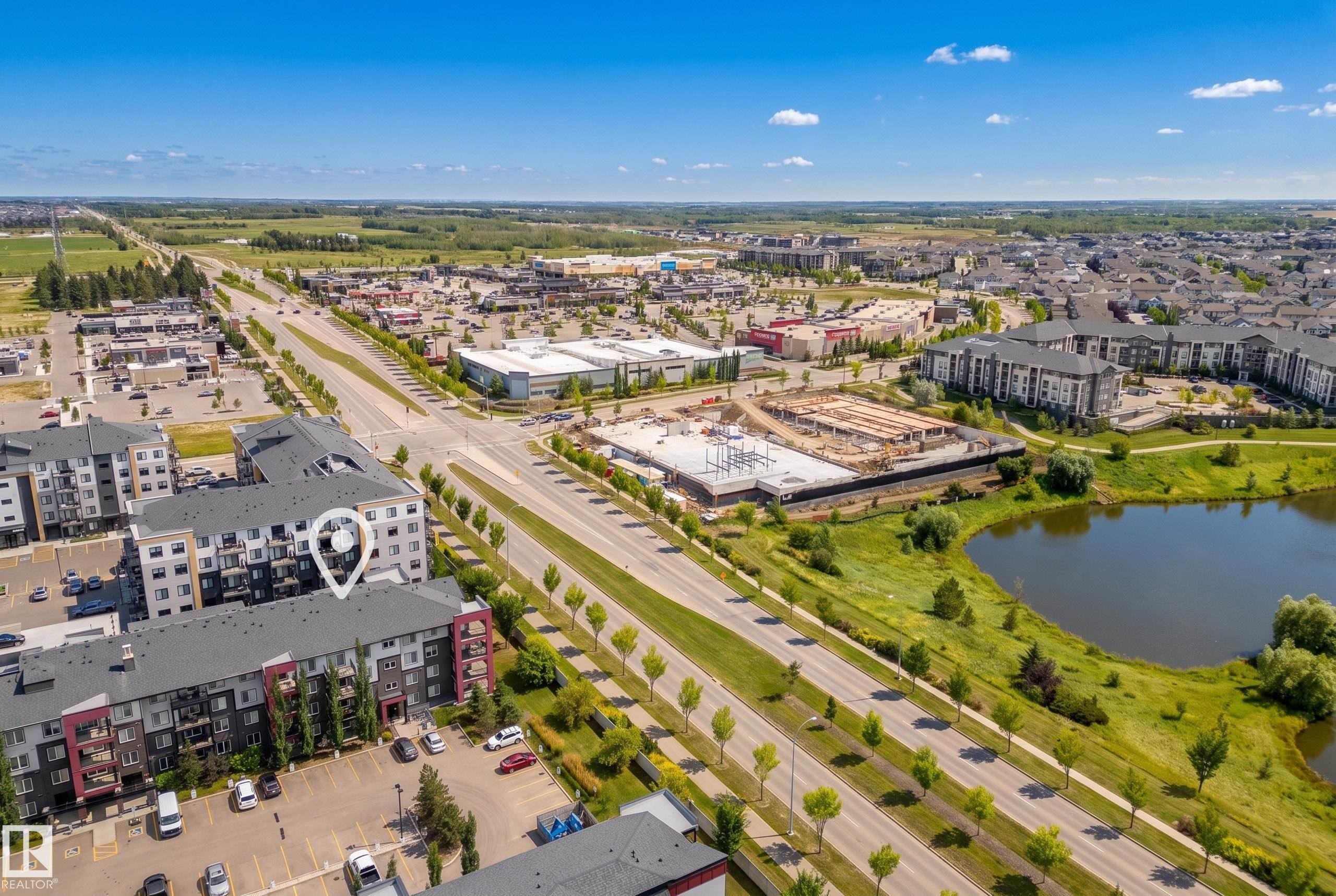 Multi-story apartment building with balconies, adjacent to a paved parking area and landscaped grounds - #419 5515 7 Av Sw, Edmonton, AB
