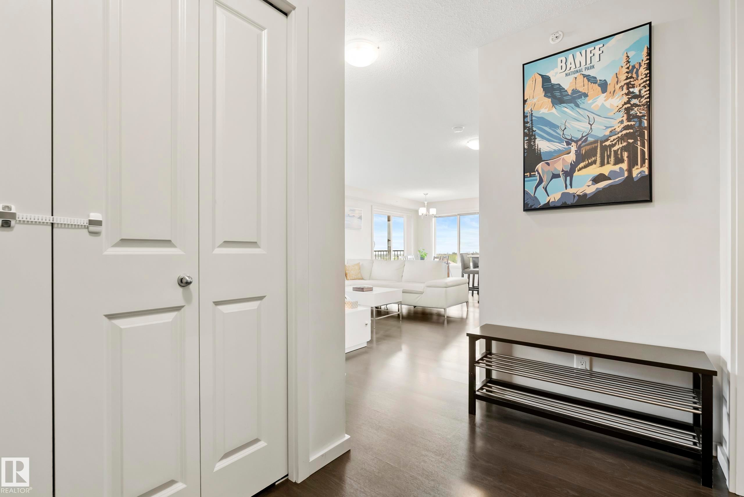 Rich wood-finish flooring throughout, white interior walls, and recessed lighting - #419 5515 7 Av Sw, Edmonton, AB