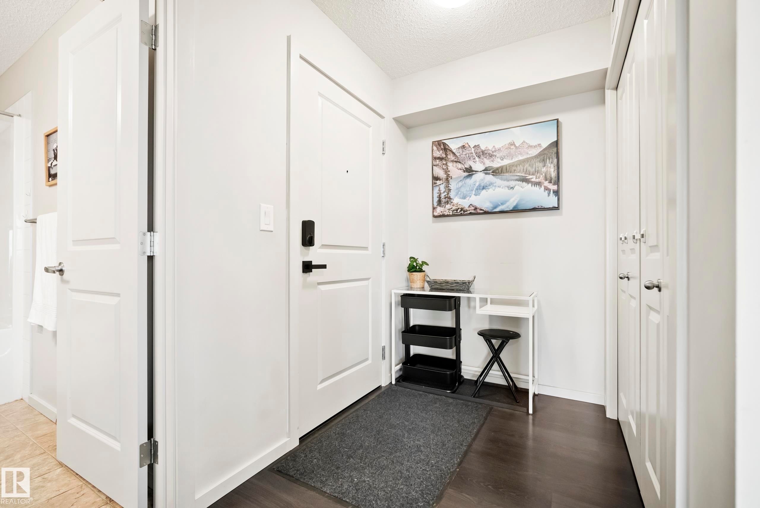 Dark wood-finish flooring with white walls and trim - #419 5515 7 Av Sw, Edmonton, AB