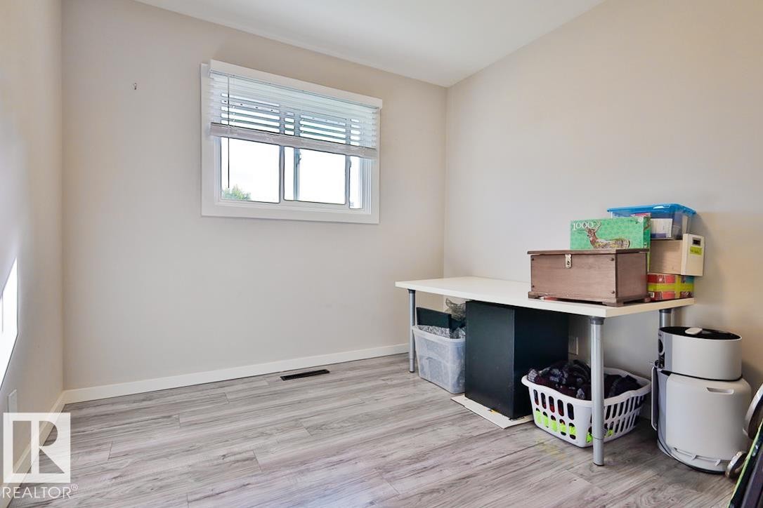 Neutral-toned walls complement wood-finish flooring - 13312 123A Street Nw, Edmonton, AB