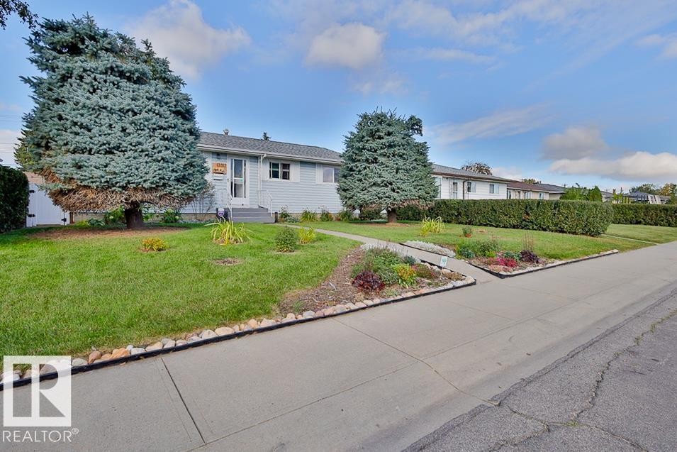 Single-story residence featuring light blue siding and a gray shingle roof - 13312 123A Street Nw, Edmonton, AB