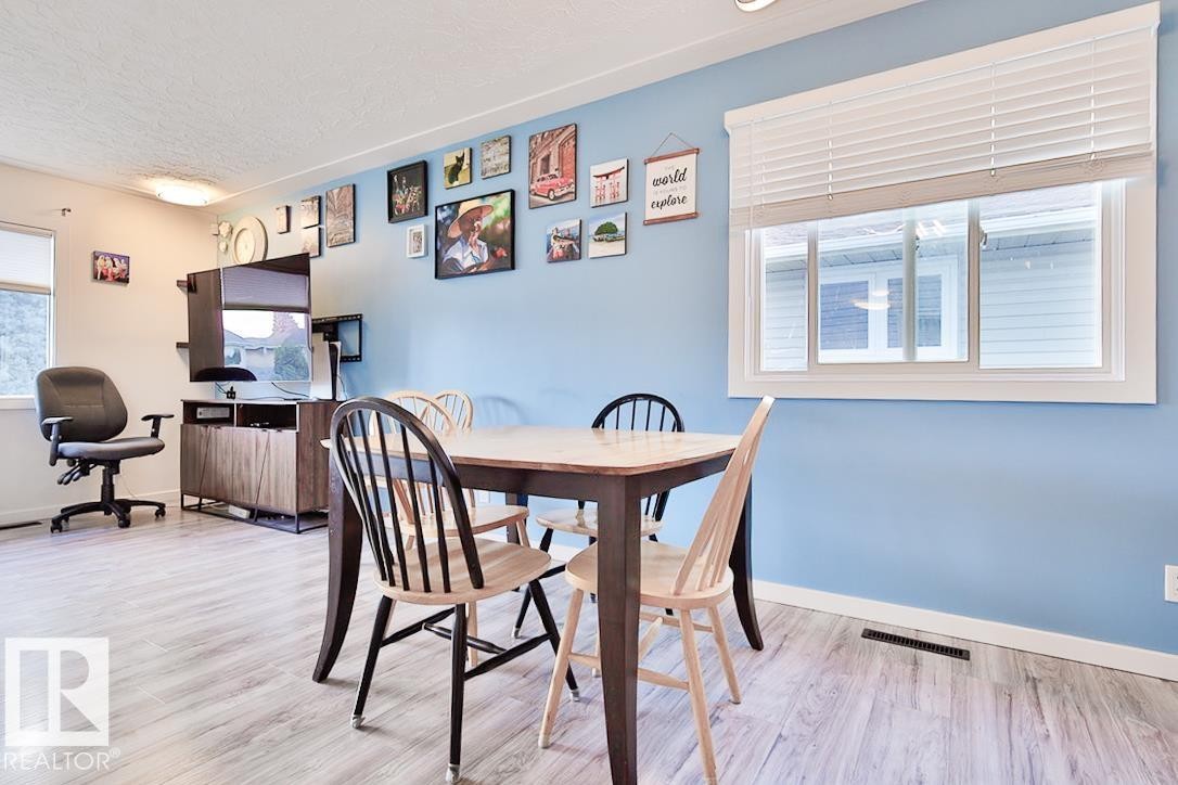 Wood-finish flooring, recessed lighting, and a window with white blinds - 13312 123A Street Nw, Edmonton, AB