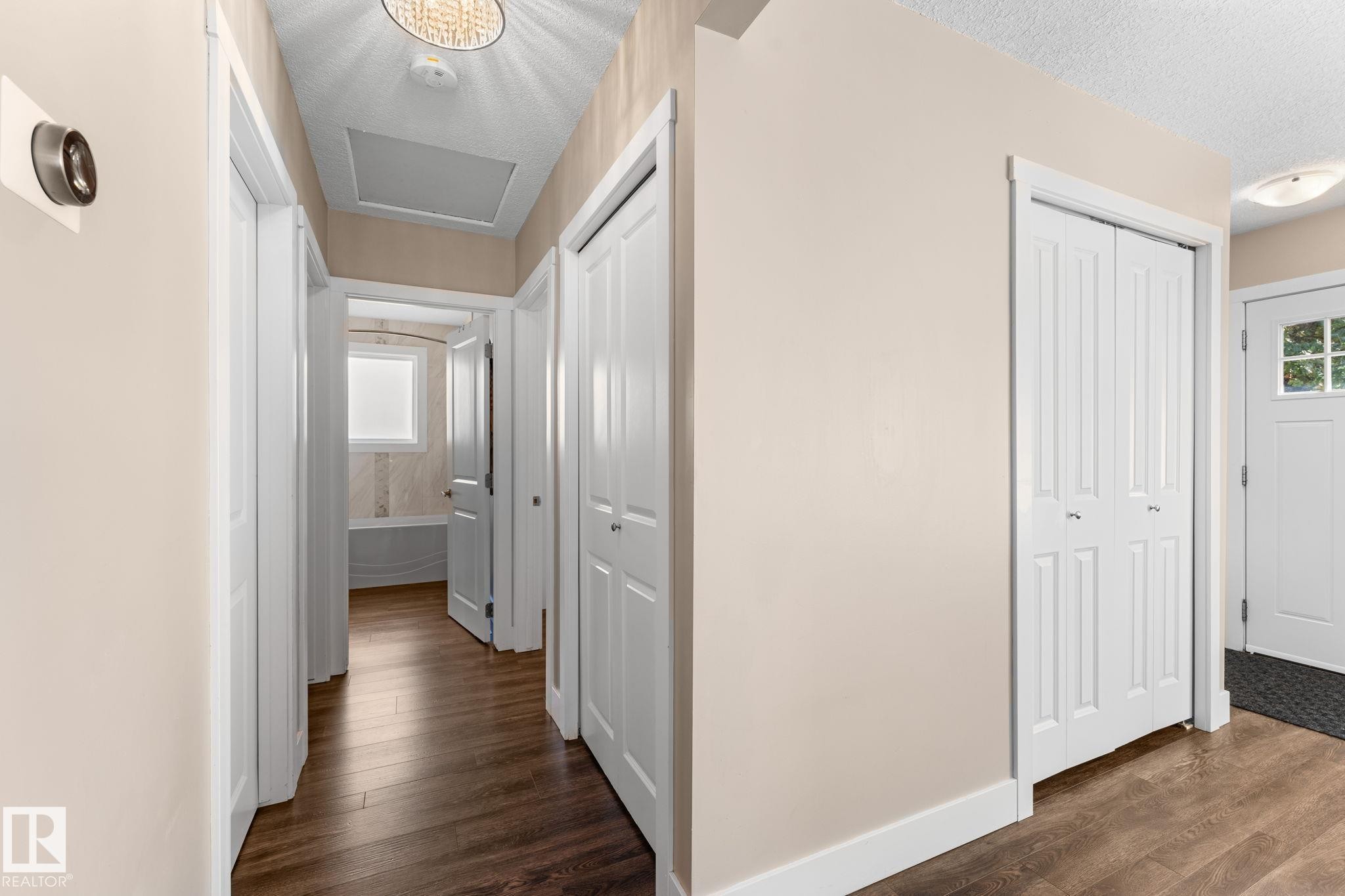 Laminate flooring, white paneled doors, and neutral wall tones - 6108 102 Avenue Nw, Edmonton, AB