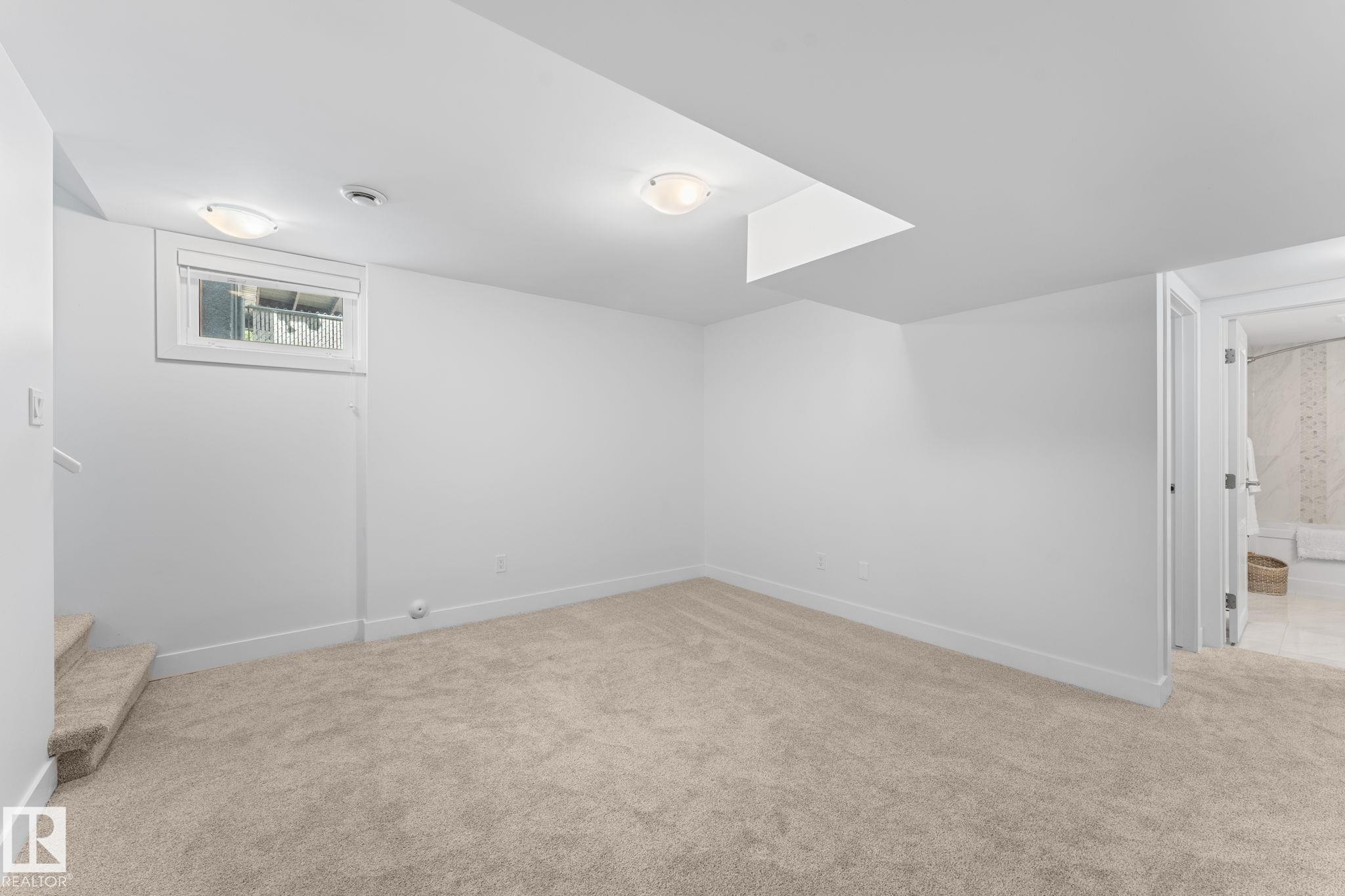 Neutral paint colors with ceiling mounted lighting, plush carpeting, and wood-finish flooring, and a visible window - 6108 102 Avenue Nw, Edmonton, AB
