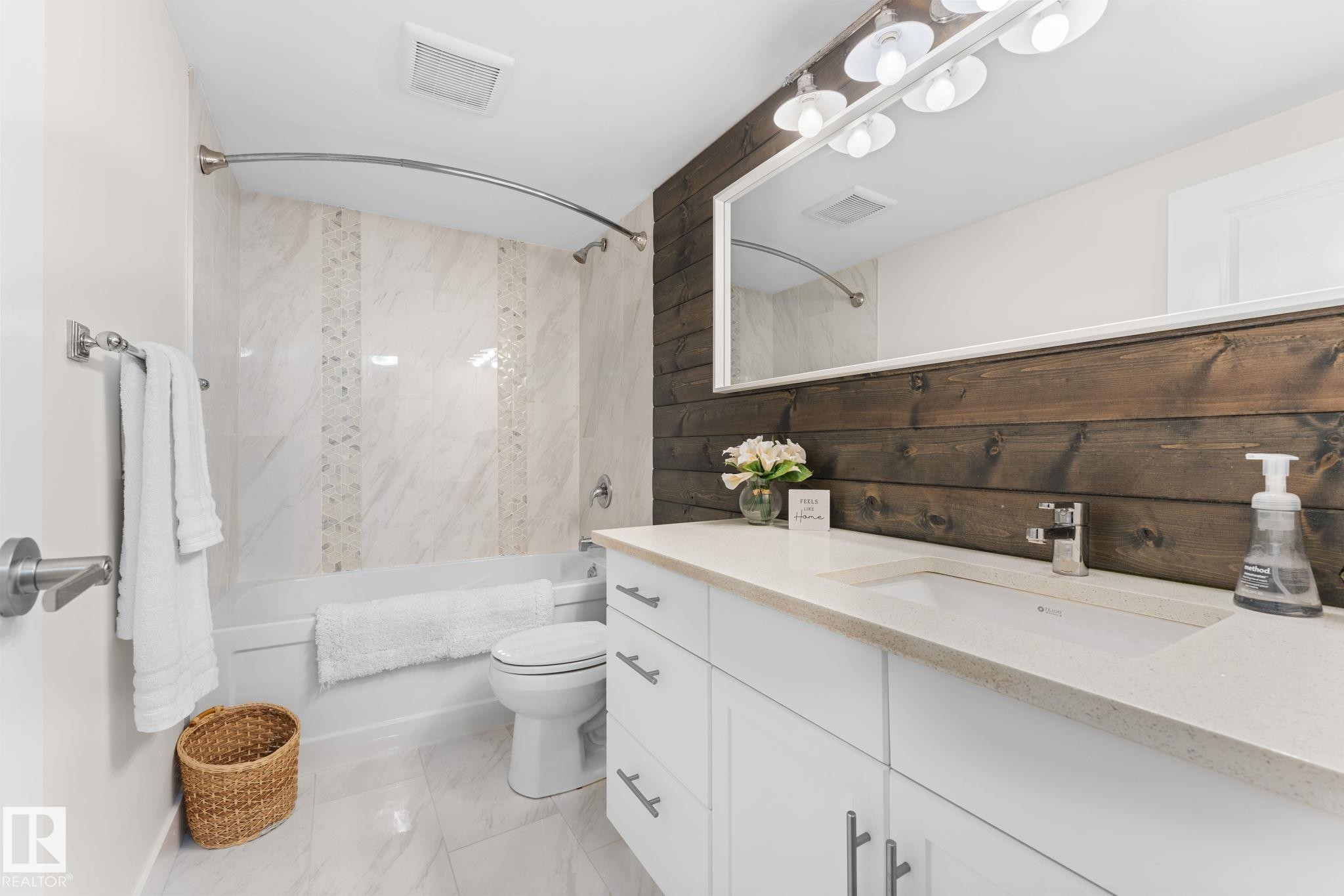 Modern vanity with an integrated sink and light-toned quartz countertop - 6108 102 Avenue Nw, Edmonton, AB