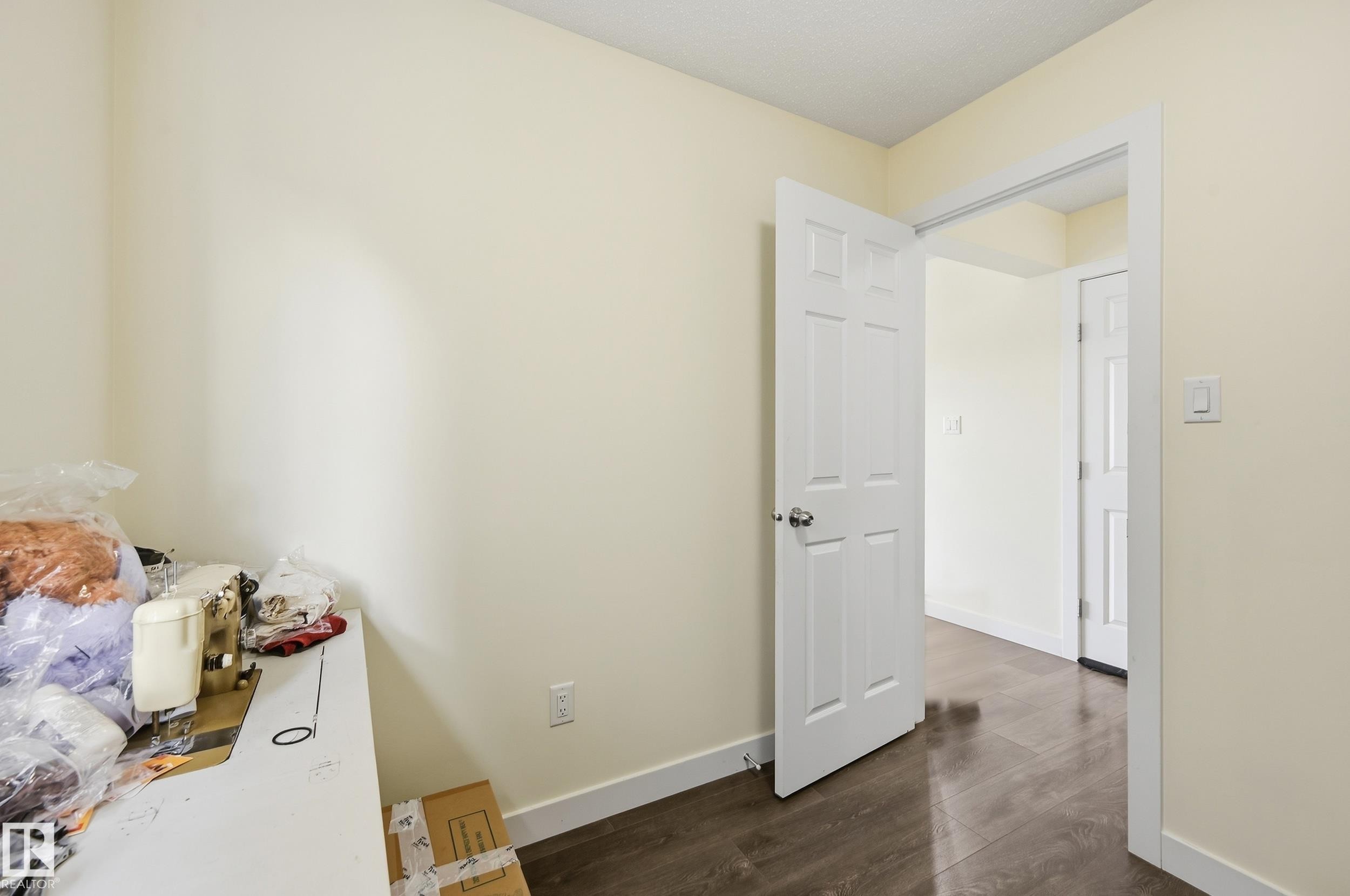 Neutral wall tones, wood-finish flooring, white paneled doors, and white trim throughout - 941 Ebbers Crescent Nw, Edmonton, AB