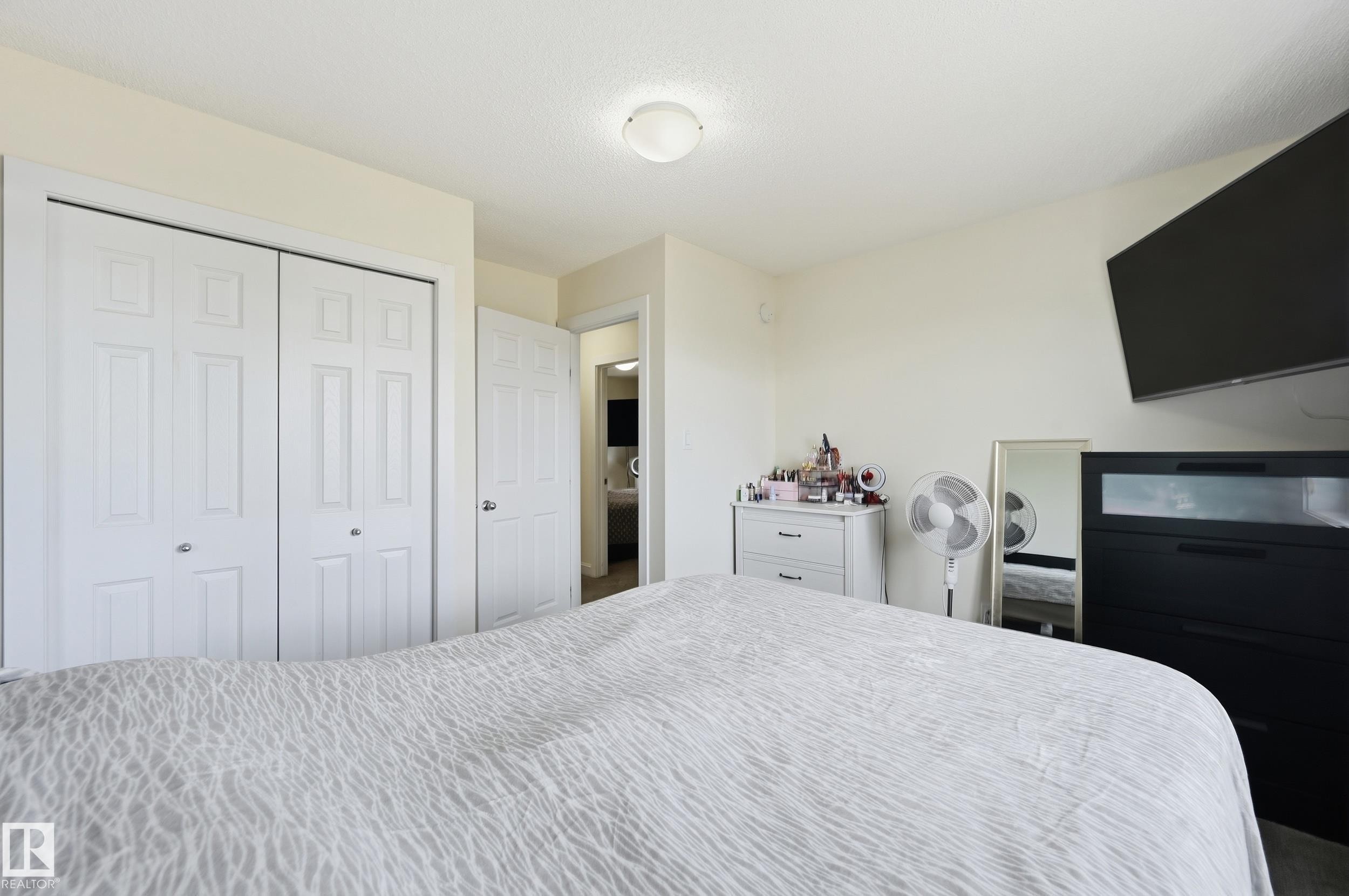 White bi-fold closet doors, light-colored walls, and a ceiling-mounted light fixture - 941 Ebbers Crescent Nw, Edmonton, AB