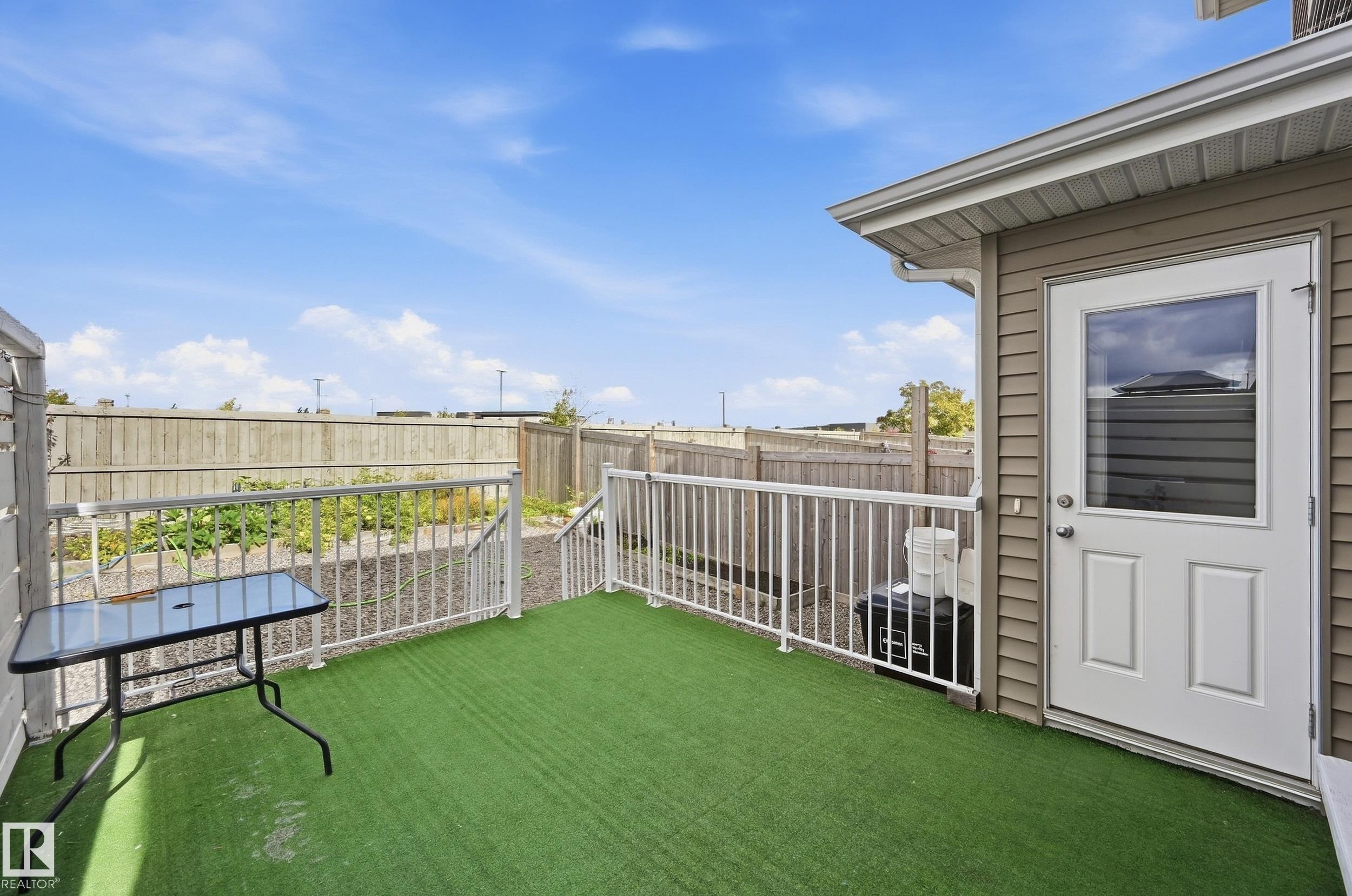 Back deck featuring green outdoor carpeting and white railings - 941 Ebbers Crescent Nw, Edmonton, AB