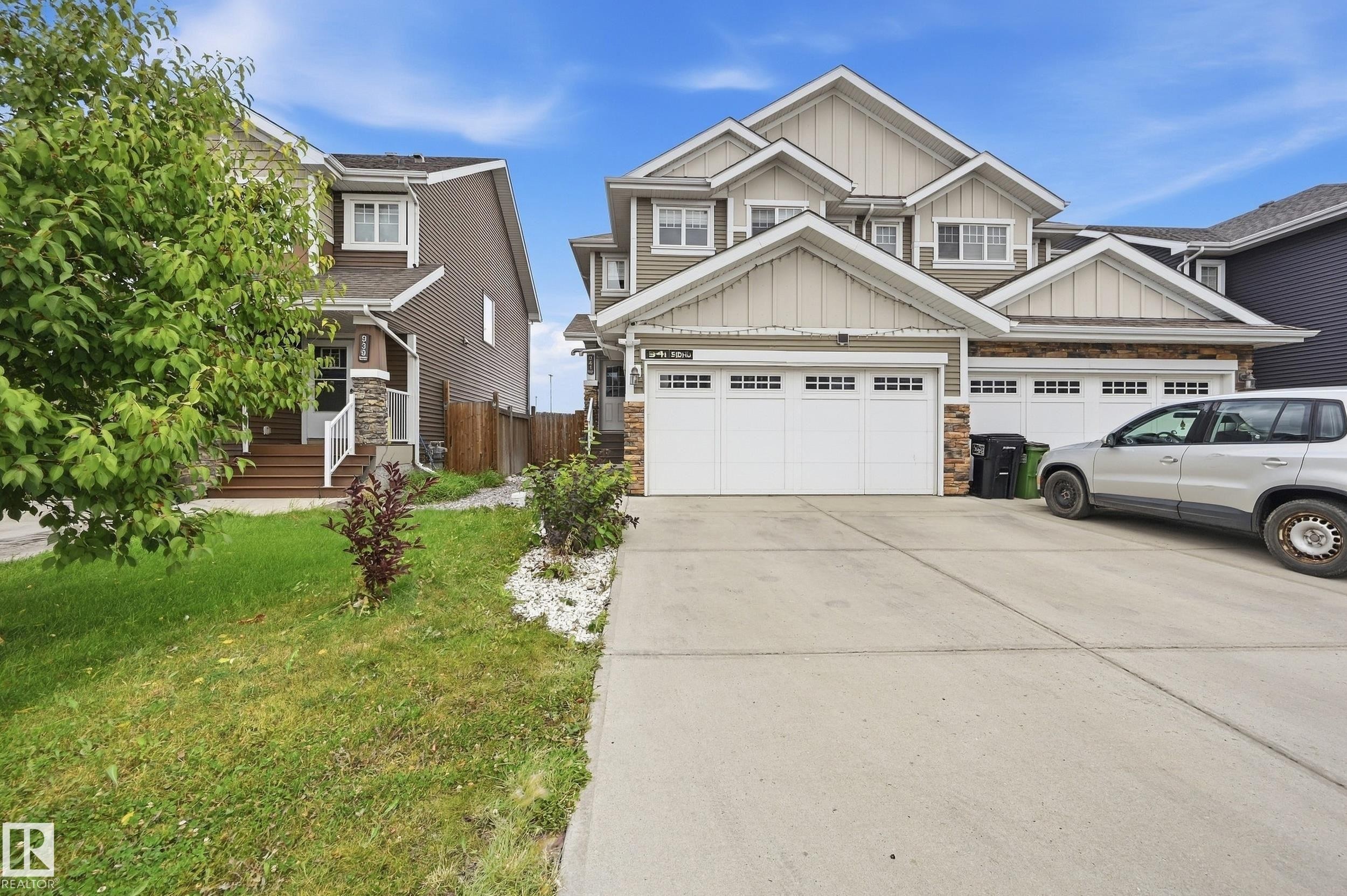 Two-story residence featuring a multi-gable roofline, stone facade accents, and a dual two-car garage - 941 Ebbers Crescent Nw, Edmonton, AB