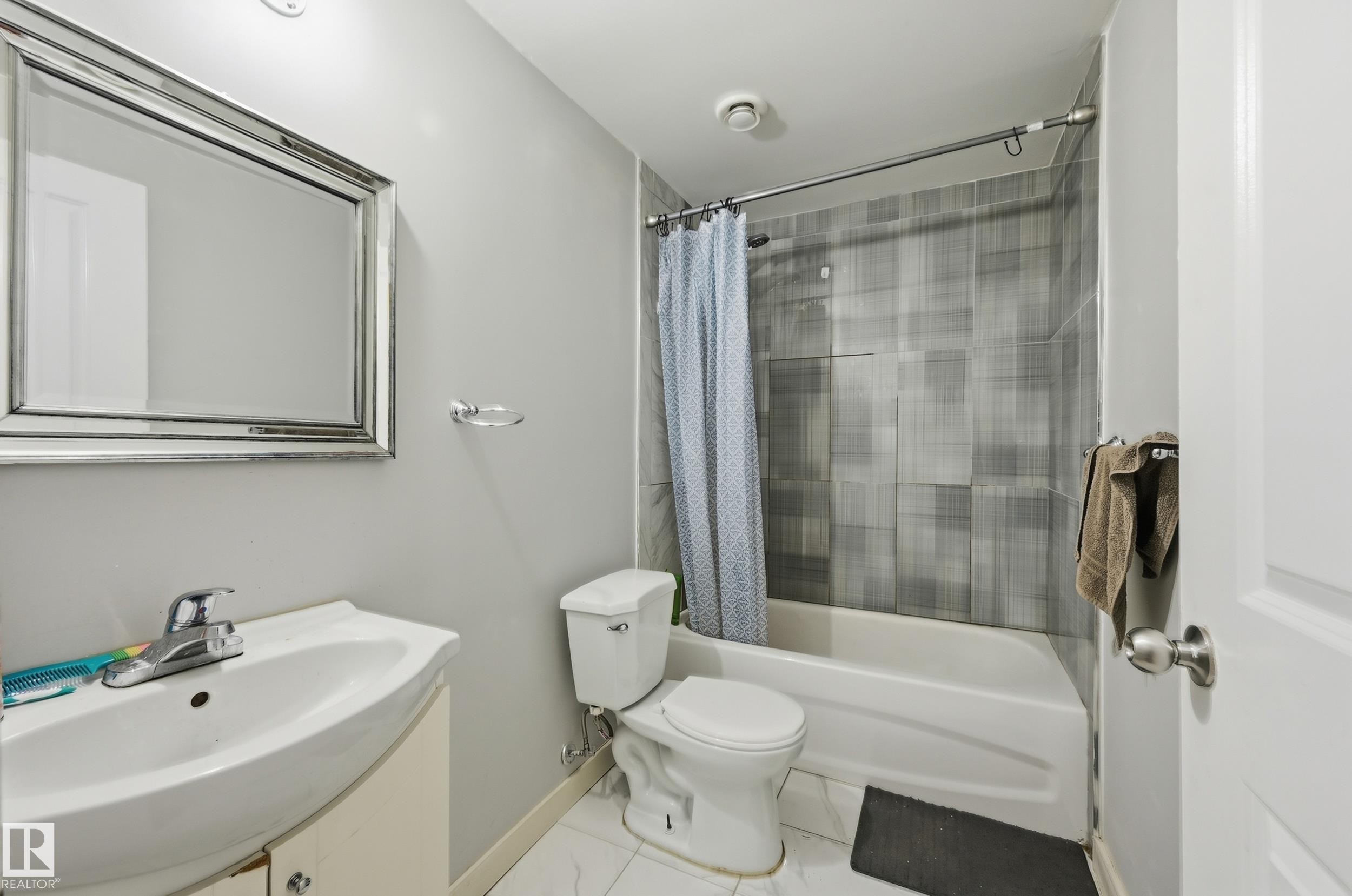Vanity with integrated sink, chrome faucet, and framed mirror - 941 Ebbers Crescent Nw, Edmonton, AB