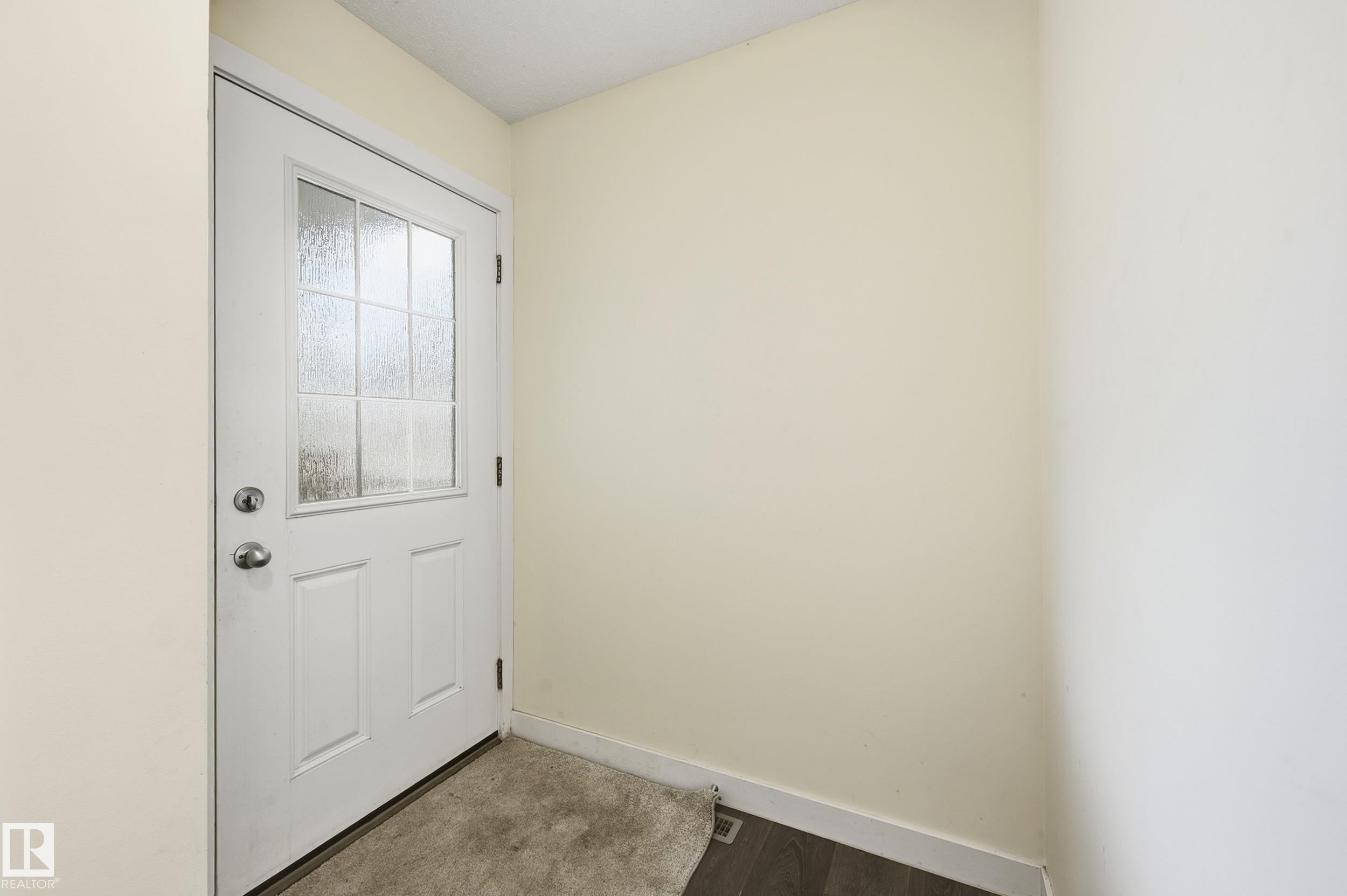 White door with decorative glass inserts, chrome hardware, and light-toned walls - 941 Ebbers Crescent Nw, Edmonton, AB