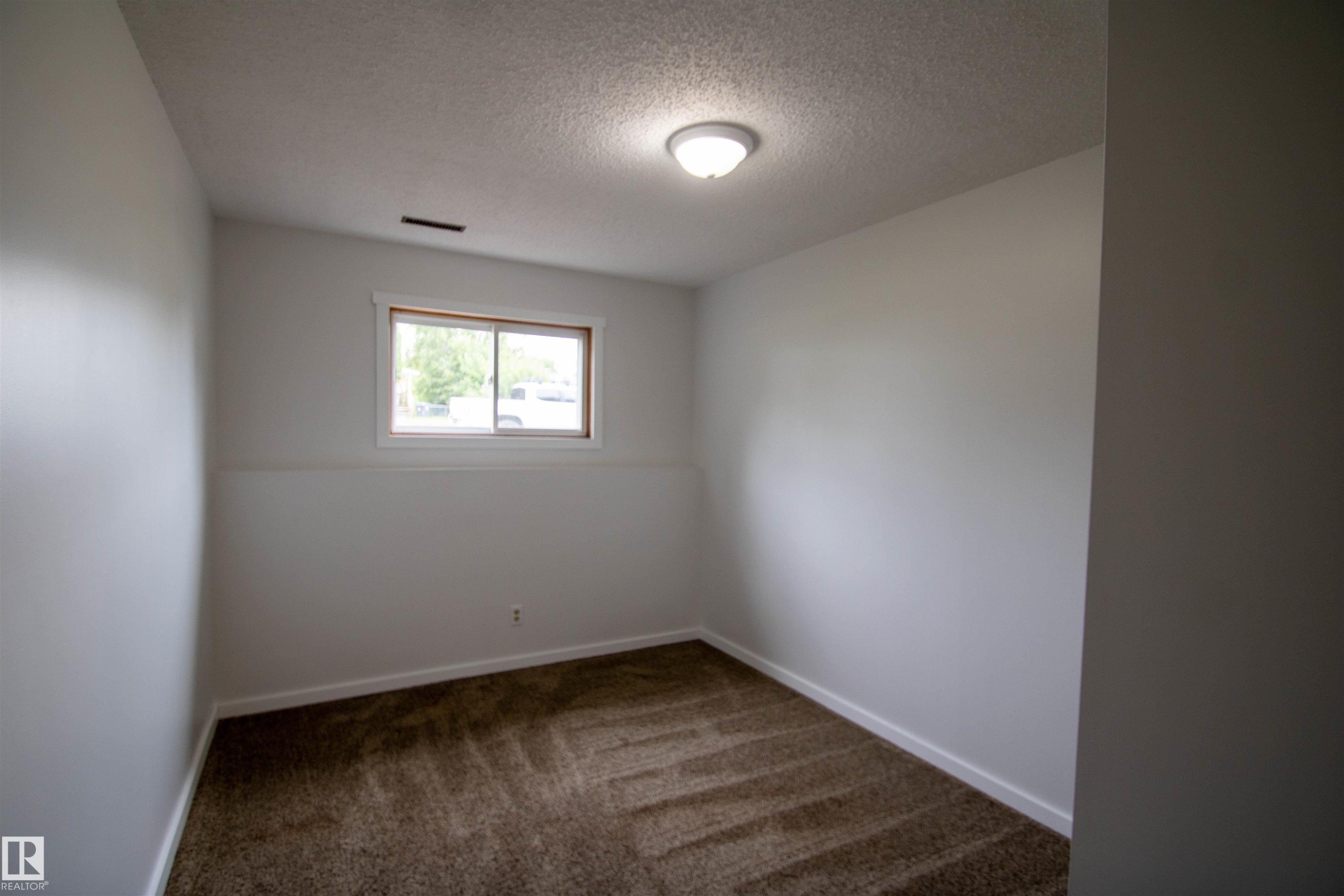 Room featuring neutral wall tones and textured brown carpeting - 4725 45 Ave, St. Paul Town, AB - Indoor Photo Showing Other Room
