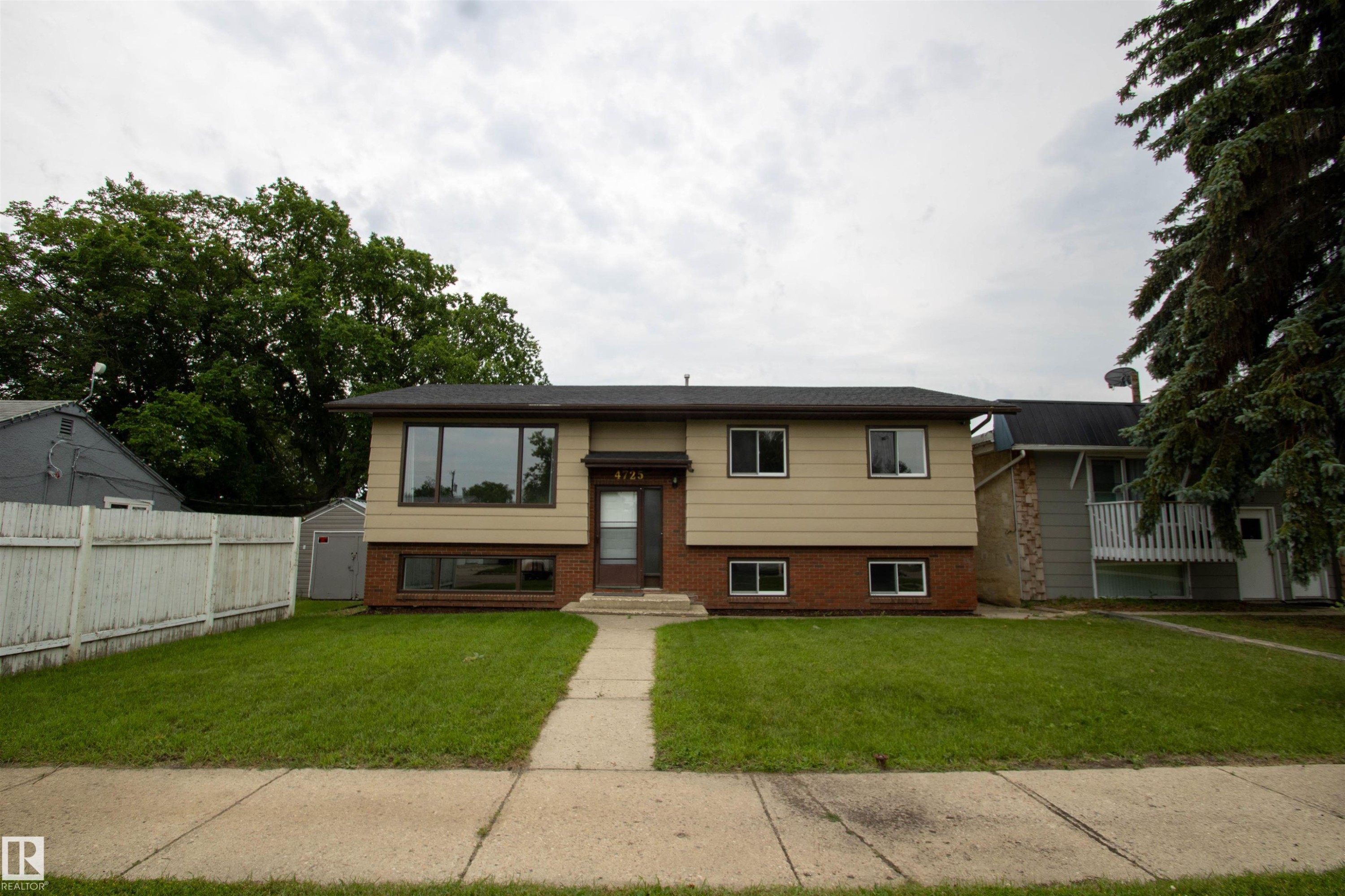 Split-level residence featuring a beige facade and a brick lower level - 4725 45 Ave, St. Paul Town, AB - Outdoor