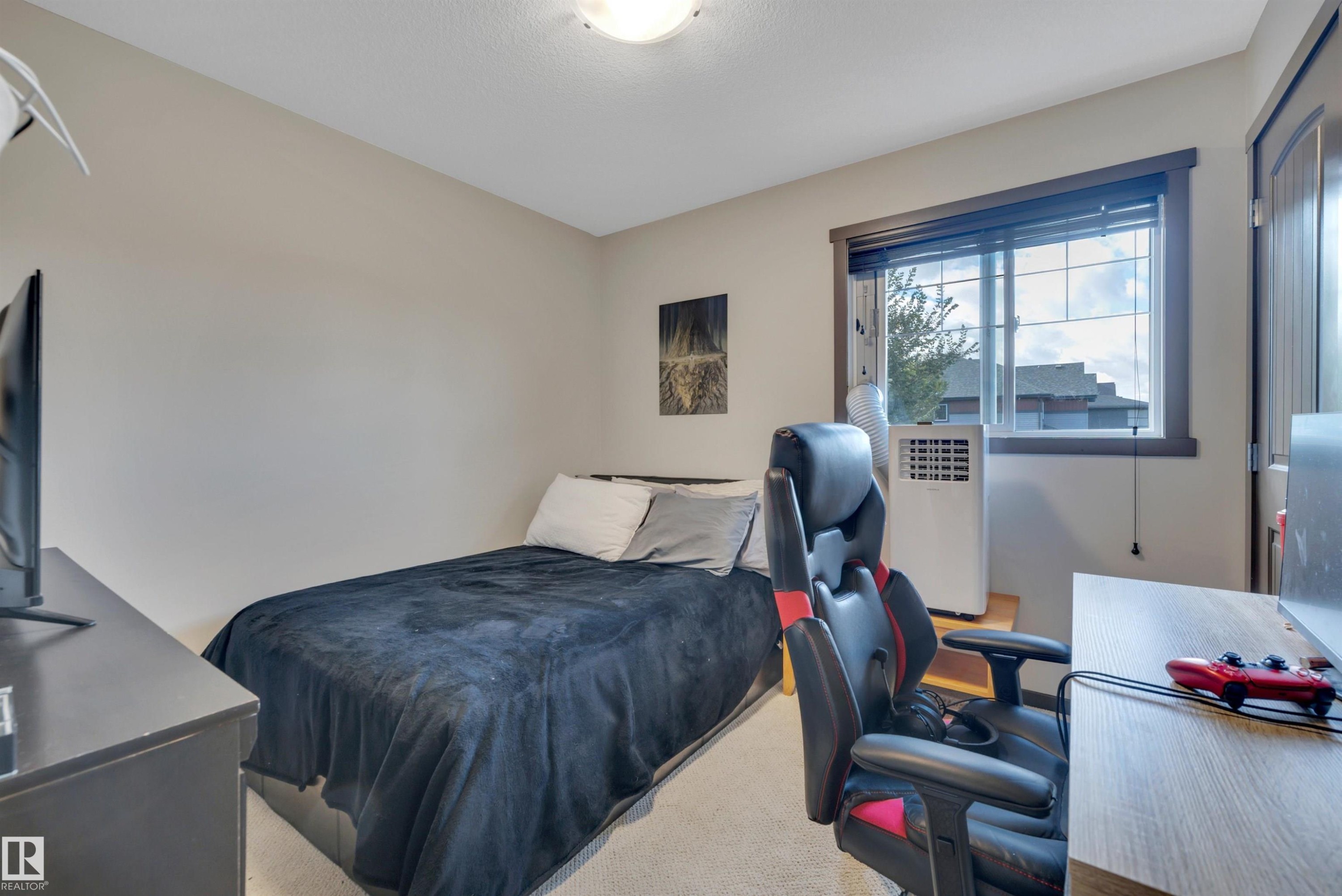 Recessed lighting illuminates neutral-toned walls, contrasting with dark window trim and a paneled door - 12903 205 Street Nw, Edmonton, AB