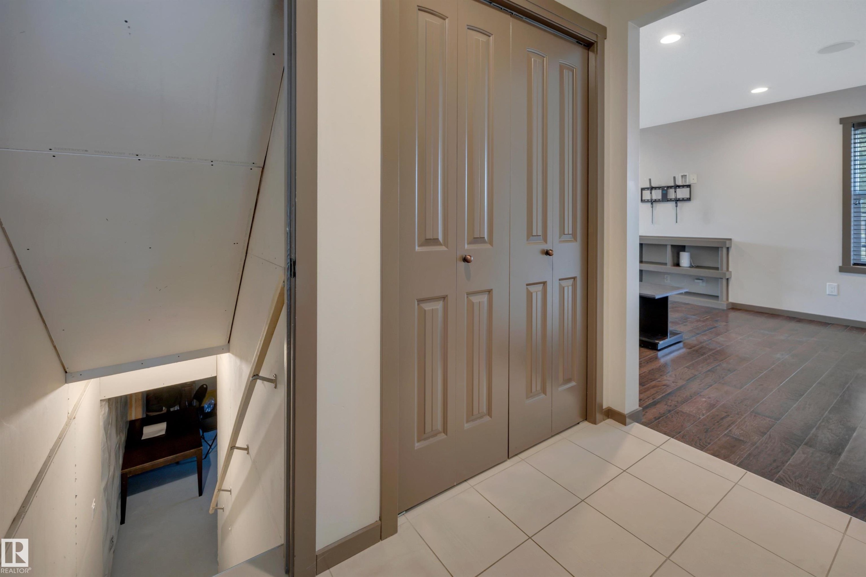 White tile flooring, paneled bifold doors, wood-finish flooring, recessed lighting, and a white wall finish - 12903 205 Street Nw, Edmonton, AB