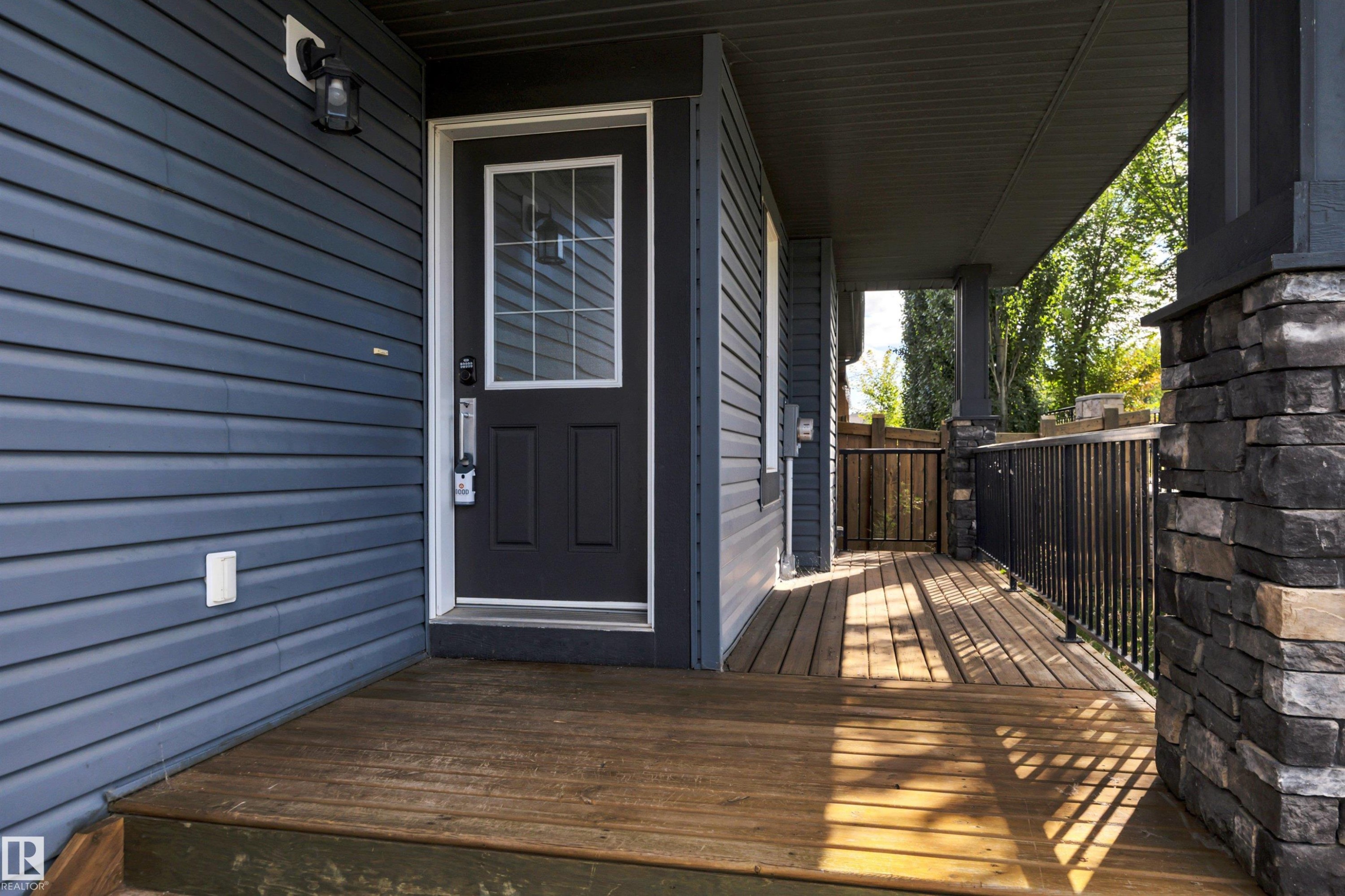Front entry with a dark paneled door, decorative glass insert, and sidelight - 12903 205 Street Nw, Edmonton, AB