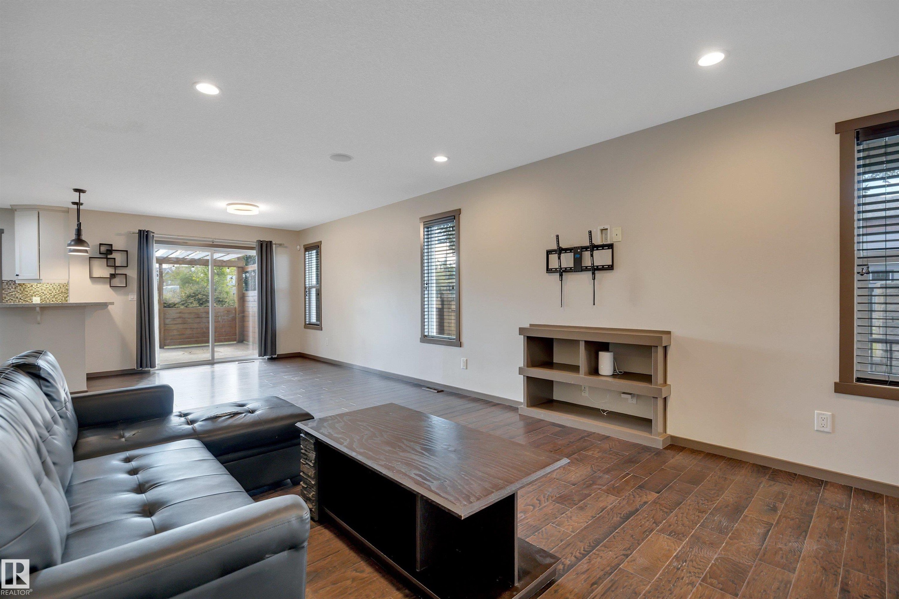 Wood-finish flooring throughout, recessed ceiling lighting, and multiple windows with blinds - 12903 205 Street Nw, Edmonton, AB