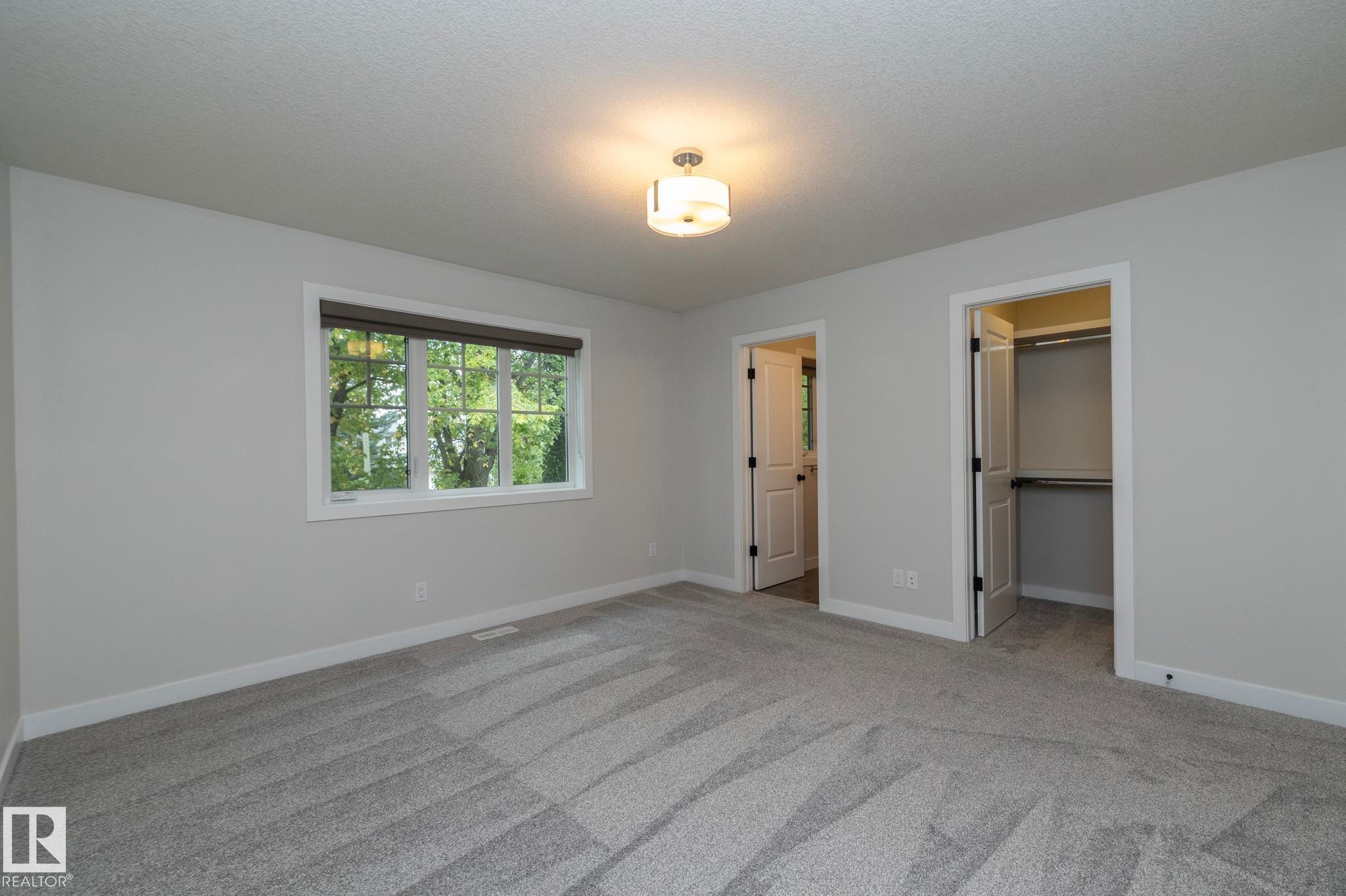 Neutral paint palette, recessed lighting fixture, large window, soft carpeting, and an integrated closet system - 53/55 Michigan Street, Devon, AB