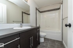Vanity with dark wood-finish cabinetry, chrome hardware, and integrated sink - 