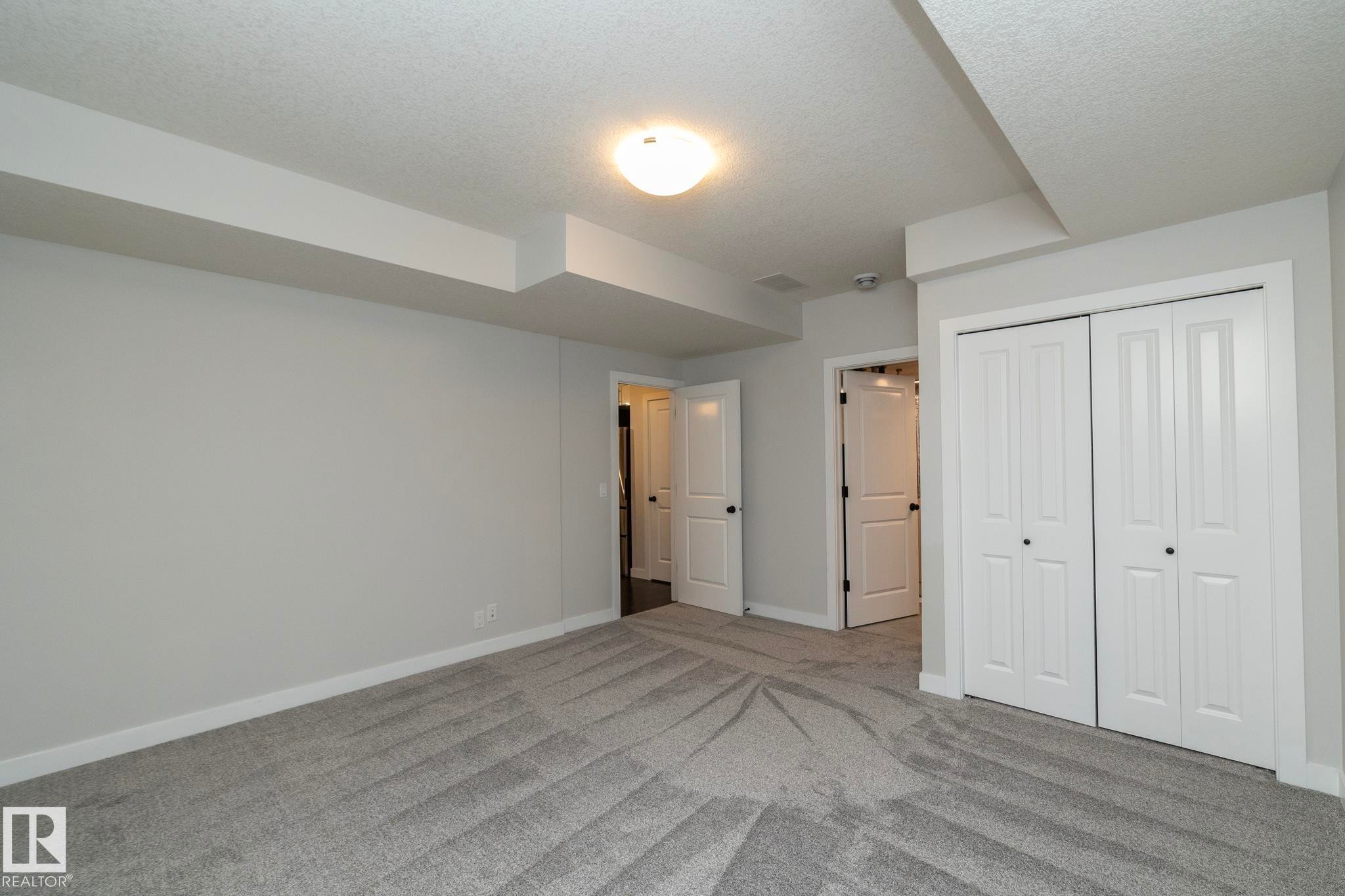 Neutral-toned walls complement the light gray carpet - 53/55 Michigan Street, Devon, AB