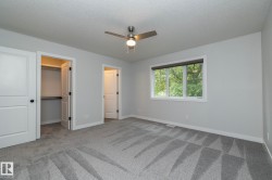 Neutral paint tones, patterned carpeting, and a ceiling fan with integrated lighting - 