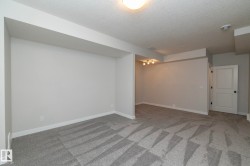 Spacious interior with neutral wall finishes and patterned carpeting - 