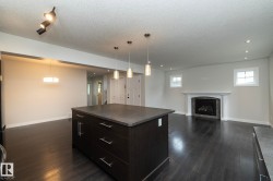 Kitchen island with dark cabinetry and a stone-finish countertop - 