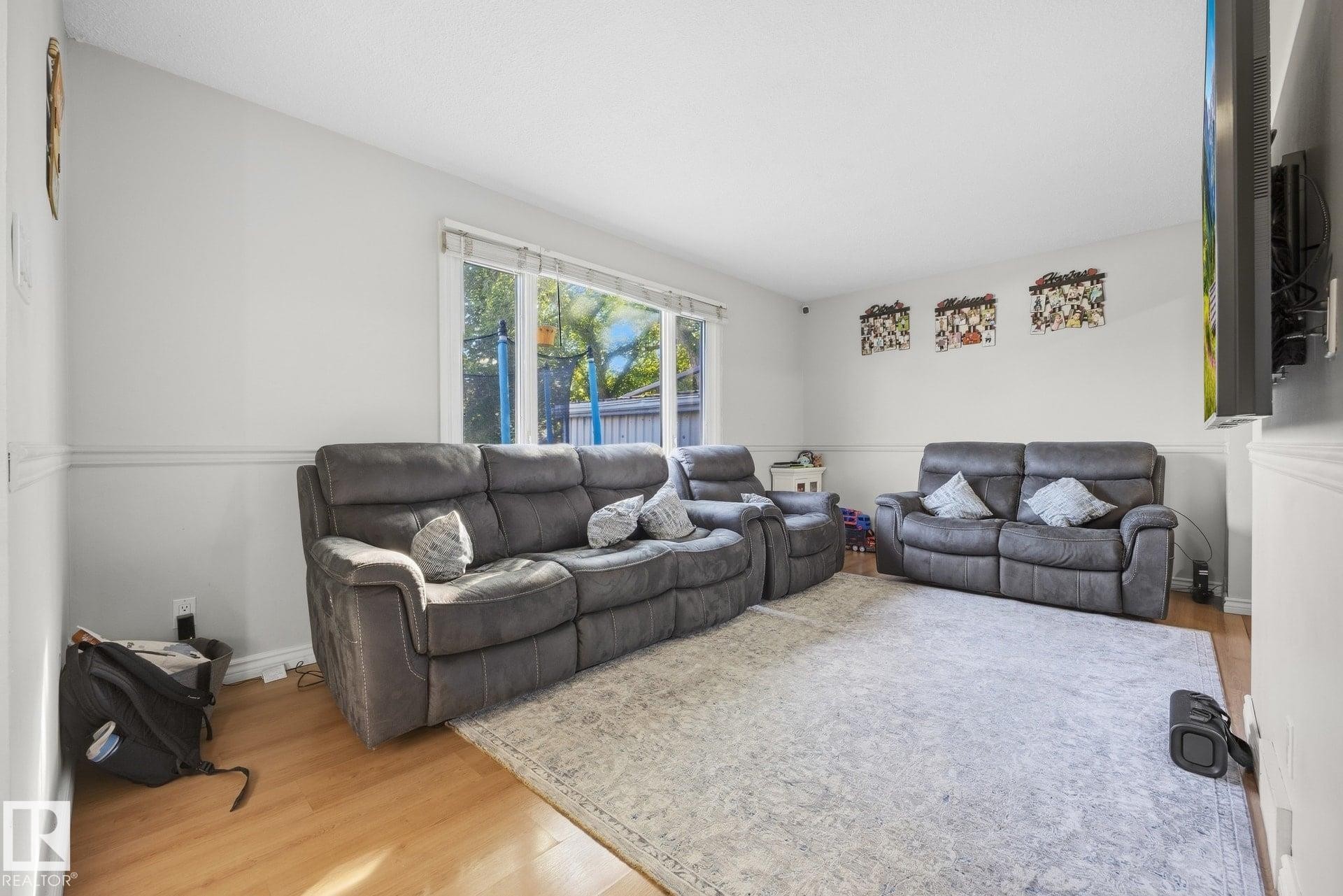 Light-toned walls with chair rail molding, large window, and wood-finish flooring - #2 14120 80 St Nw, Edmonton, AB