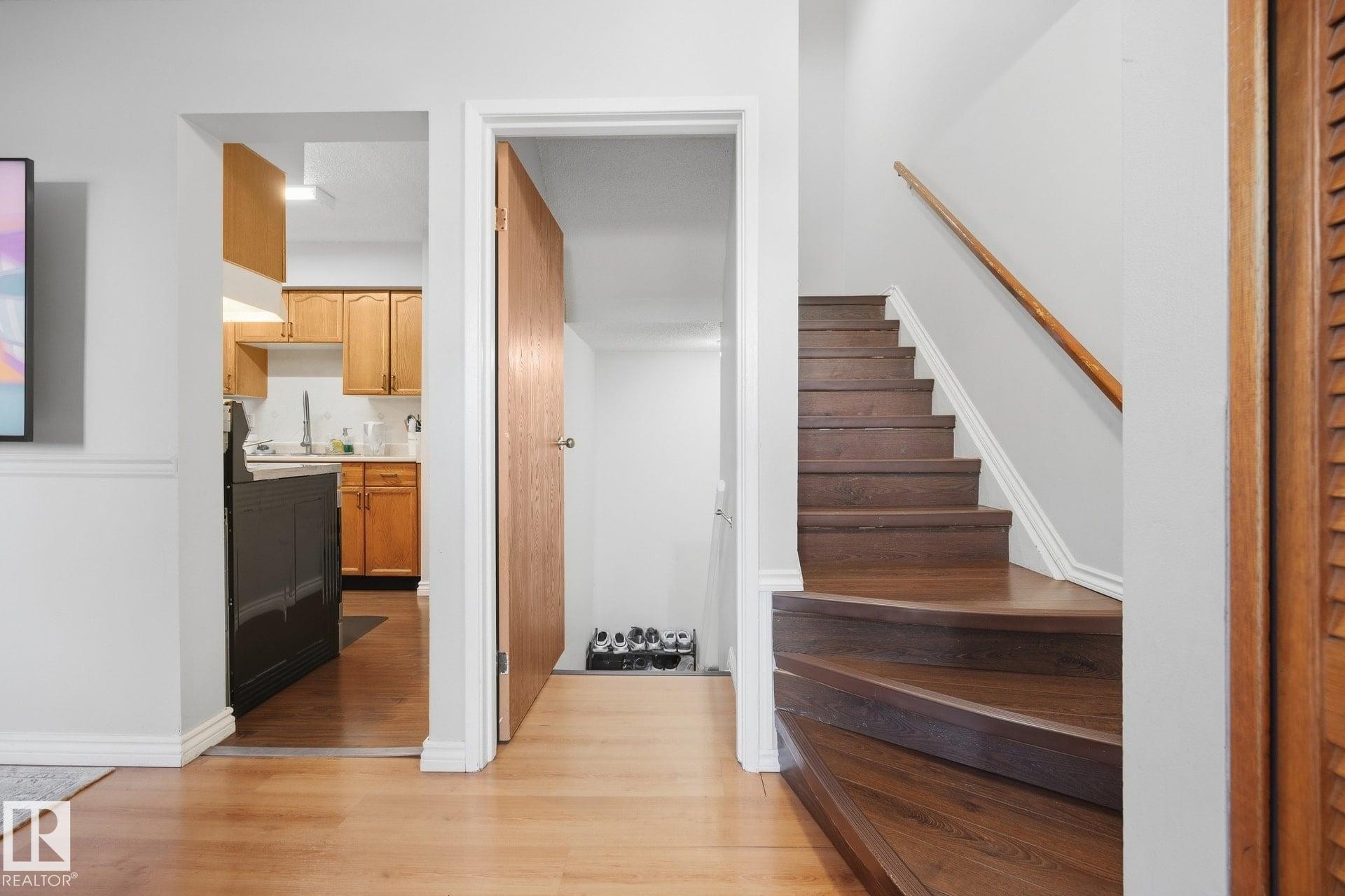 Hardwood-style flooring throughout, wood staircase with matching handrail, and kitchen with wood-finish cabinetry - #2 14120 80 St Nw, Edmonton, AB