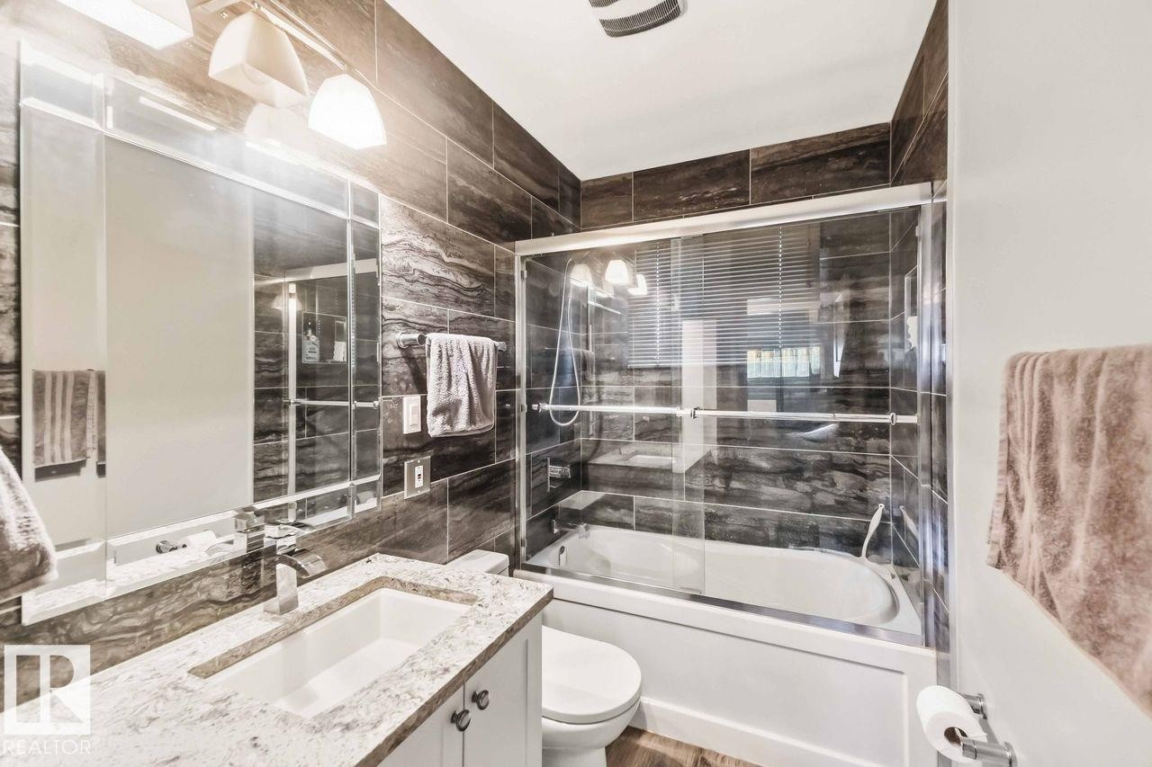 White vanity with a stone countertop and integrated rectangular sink - 13427 83 Street Nw, Edmonton, AB