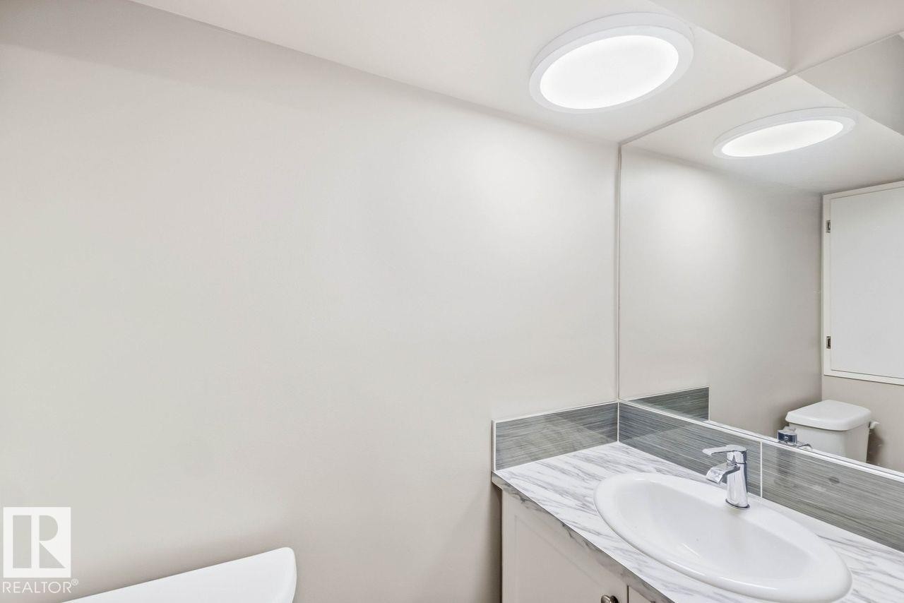 Vanity with an undermount sink, a chrome faucet, and a patterned countertop - 13427 83 Street Nw, Edmonton, AB