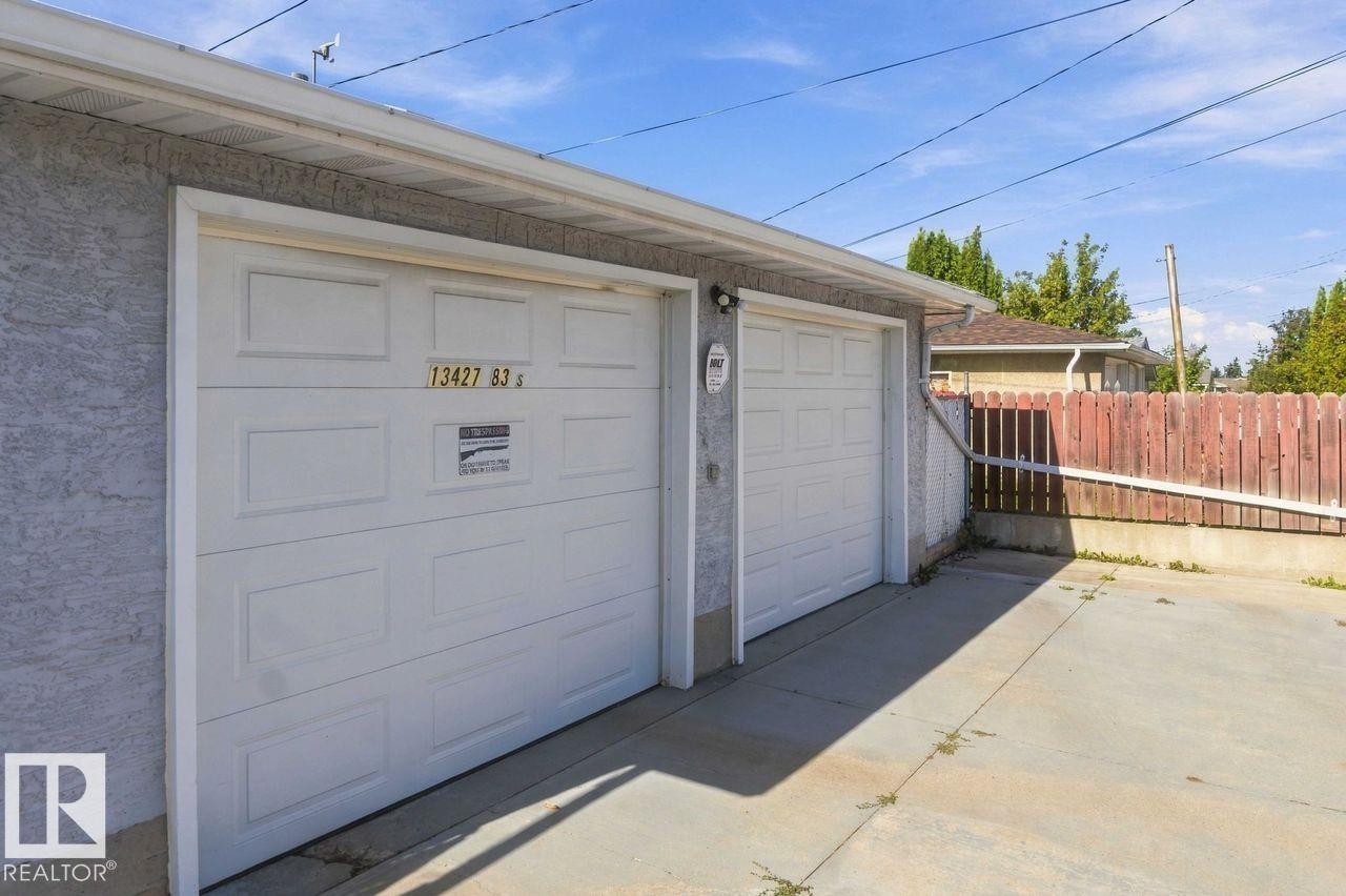 Two white panel garage doors with stucco exterior - 13427 83 Street Nw, Edmonton, AB