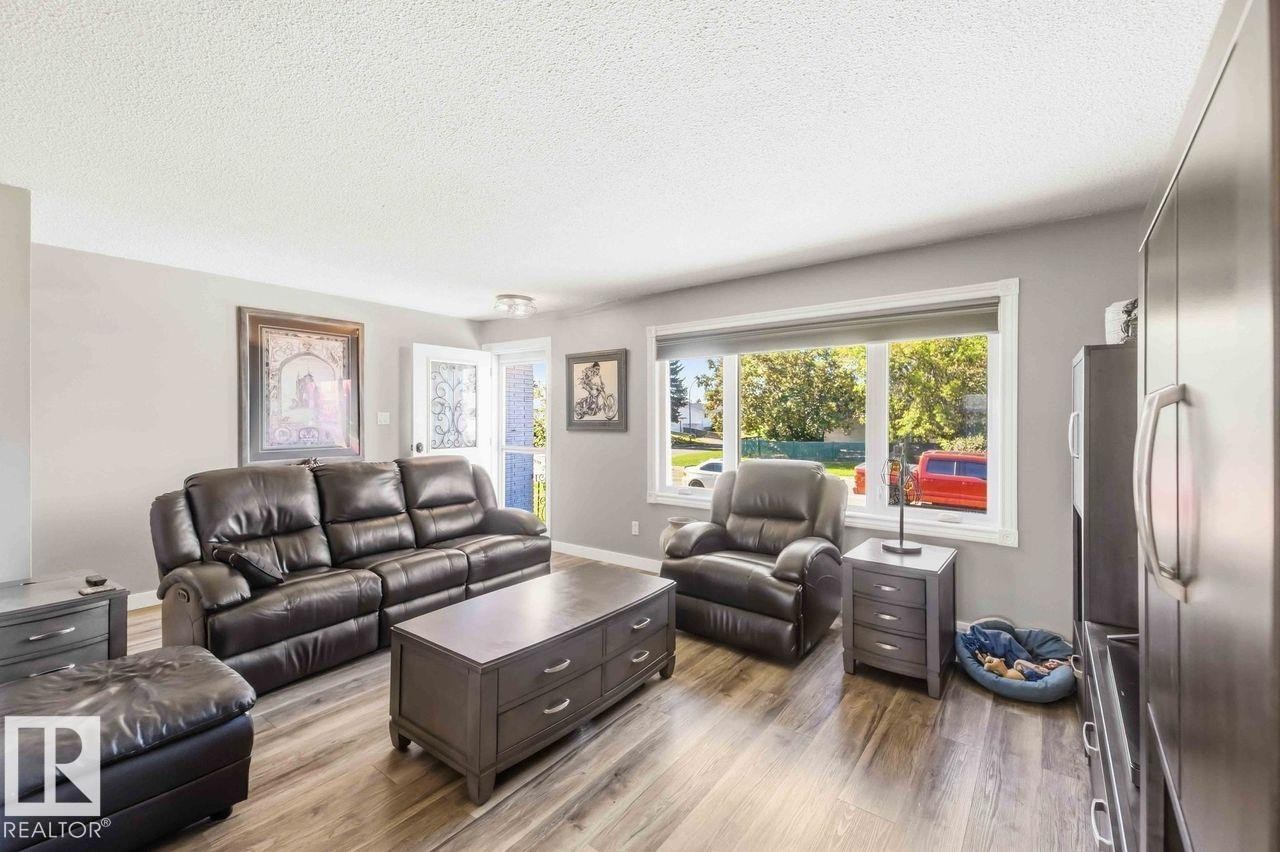 Recessed lighting, wood-finish flooring, light gray wall paint, white trim, and a prominent window - 13427 83 Street Nw, Edmonton, AB